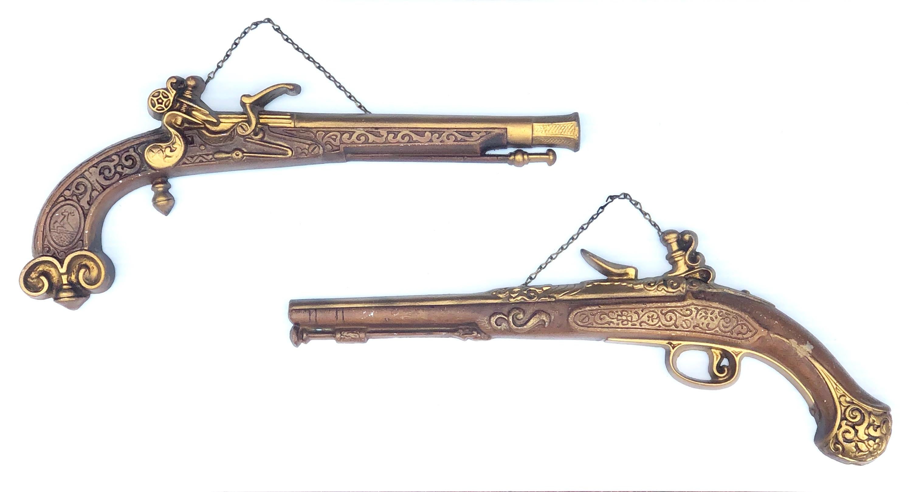 Nice patinated original finish on these pair of antique cast aluminium duelling guns by Sexton. Classic midcentury decorative pieces. In gold and brown finish painted with some scuffs and marks due to age.