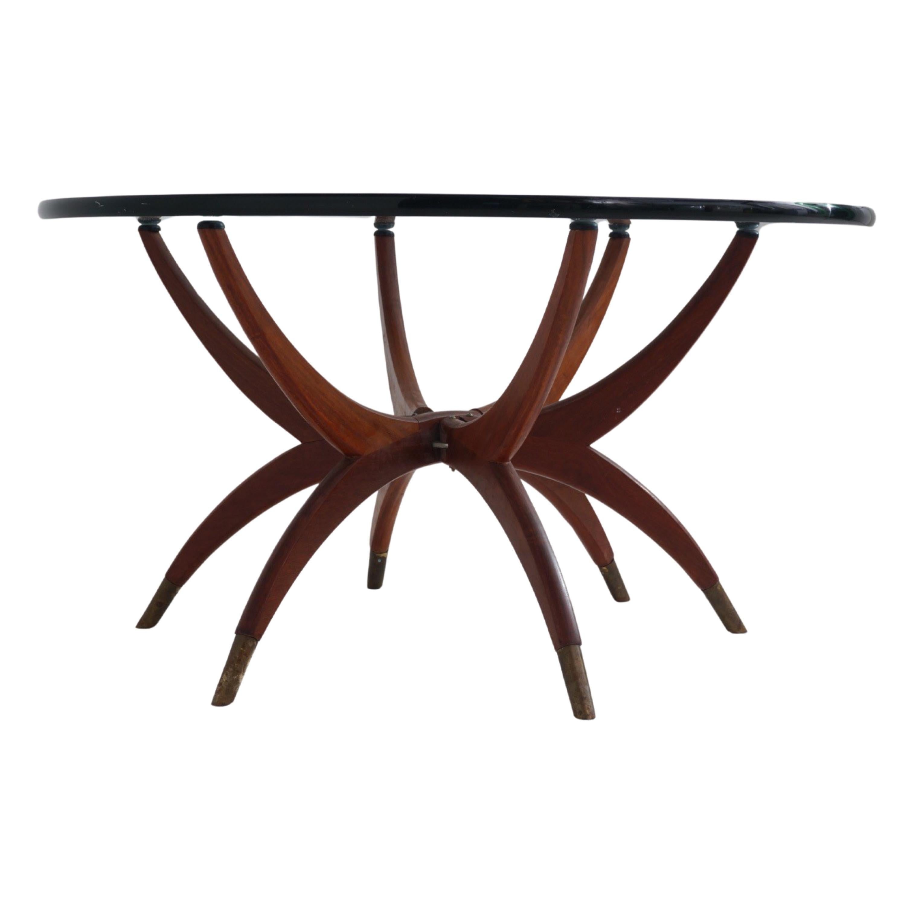 This is not your average coffee table. With legs like spider limbs dipped in a deep patina brass, it's has the ultimate in cool Mid-Century Modern vibes. A thick round glass top perches atop the foldable walnut base. Need to clear the living room in