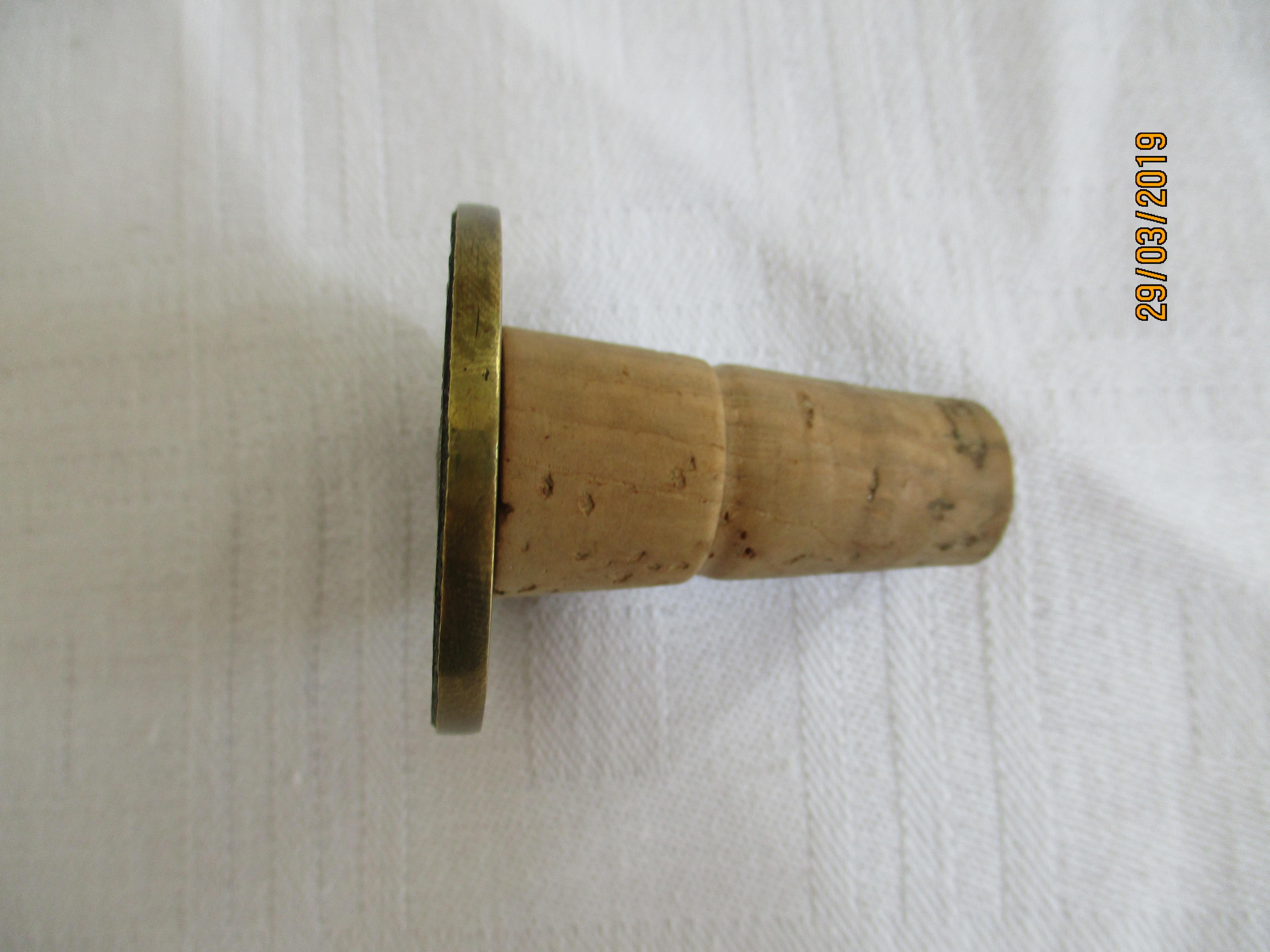 For sale is a beautiful bottle stopper with a historical coin motive. It was crafted from brass and cork and designed by the renowned workshops of Carl Auböck in Austria. It represents the typical style of the 50s and German Bauhaus, where Auböck