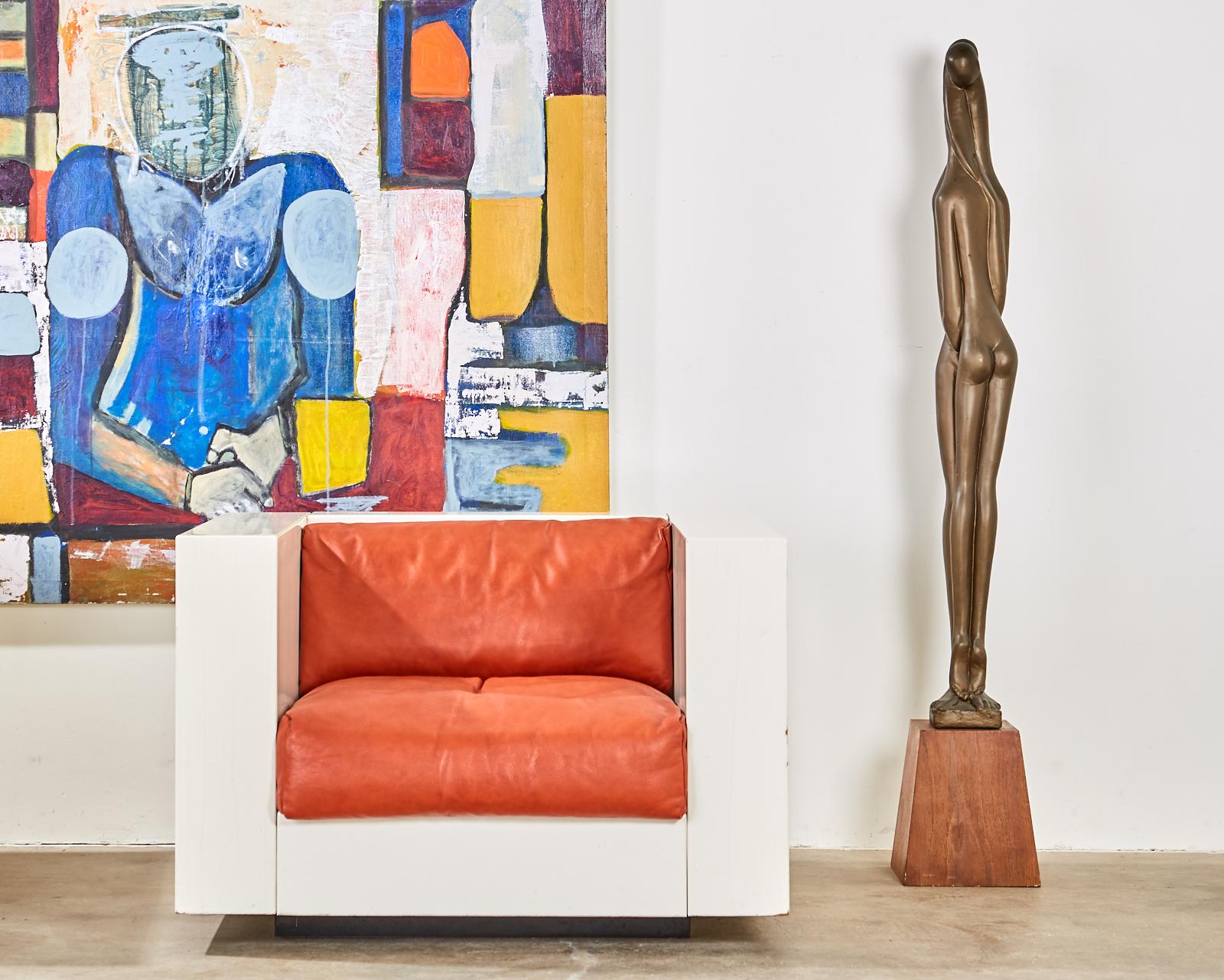 Tall Mid-Century Modern composite sculpture by Austin Productions. Features a figural sculpture of two lovers embracing. The abstract figures have a lovely patinated bronze finish. Signed and dated on bottom 1966. Mounted on a tapered wooden