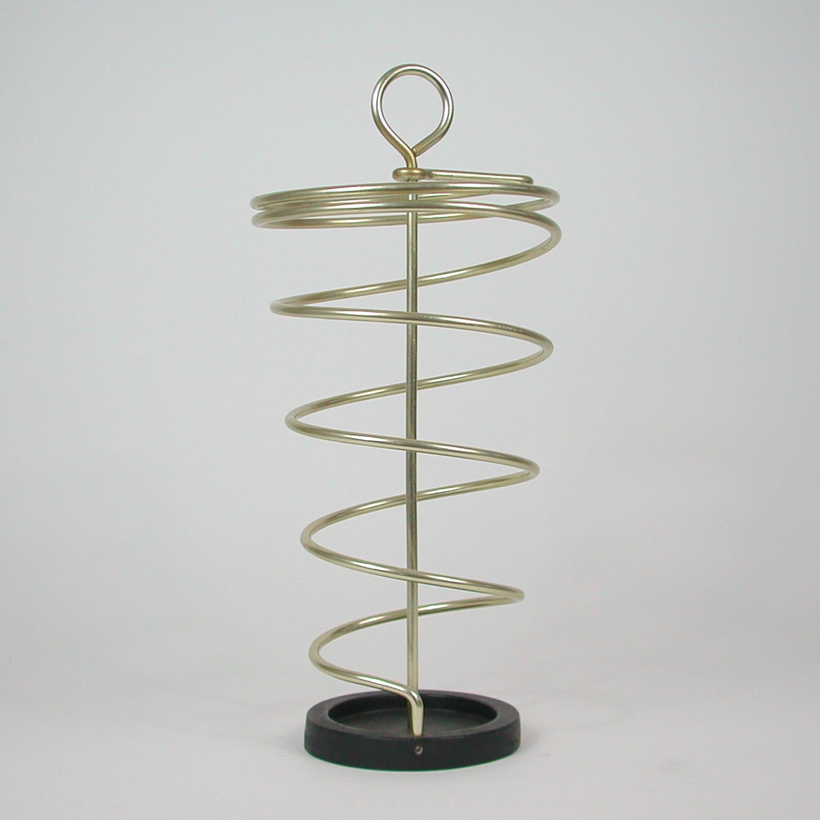 This midcentury atomic umbrella stand was designed and manufactured in Austria in the 1950s.
It features a gold anodized aluminum frame and black cast iron base.