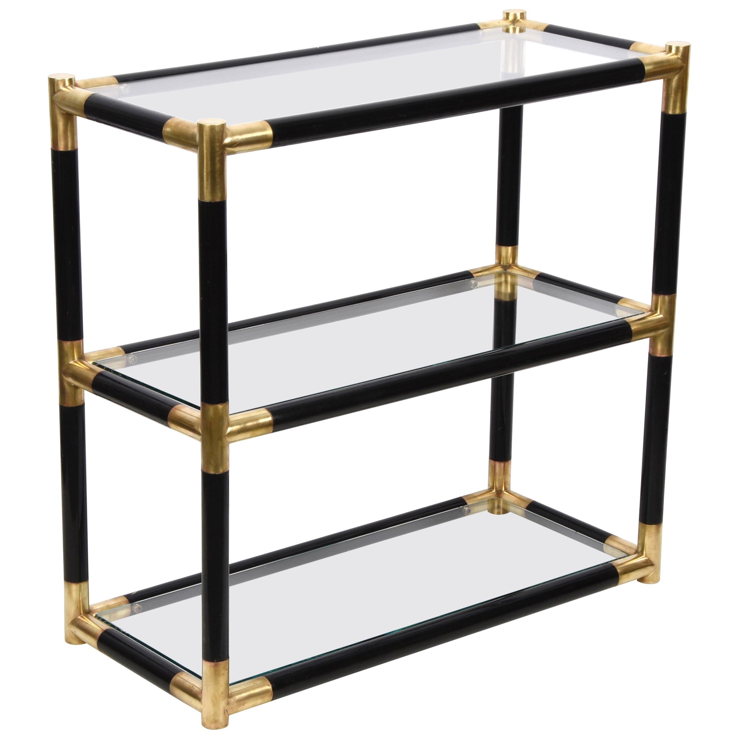 Amazing midcentury bookcase in lacquered black Bamboo with half-century brass and three crystal shelves. This fantastic bookcase was produced in Italy during the 1970s.
Attributable to Tommaso Barbi ?

This bookcase or étagère conveys elegant and