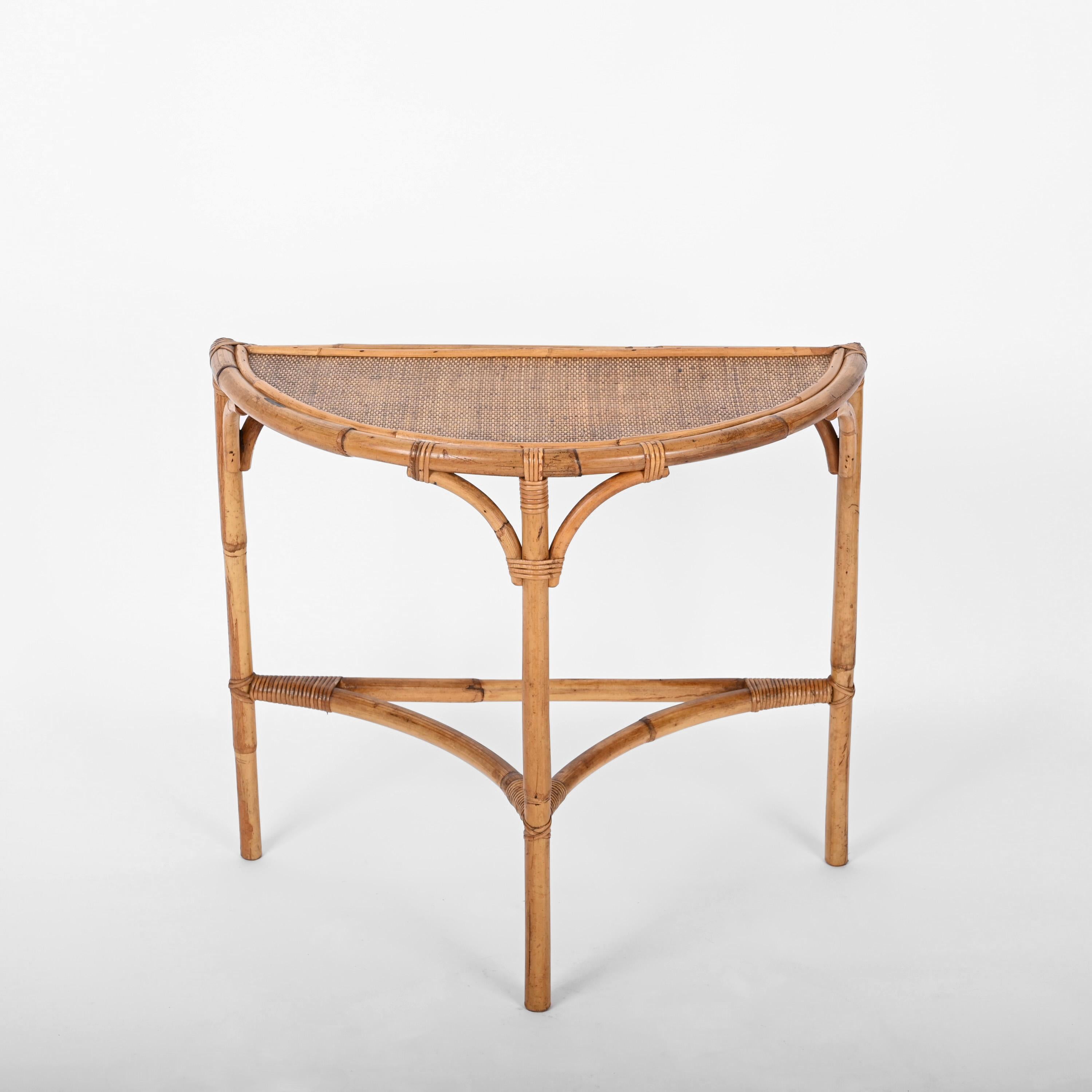 Charming arched bamboo and rattan console table with crescent top. This piece was produced following the style of Franco Albini in Italy during the 1970s.

This console table has a structure laying on three bamboo legs joined together. This