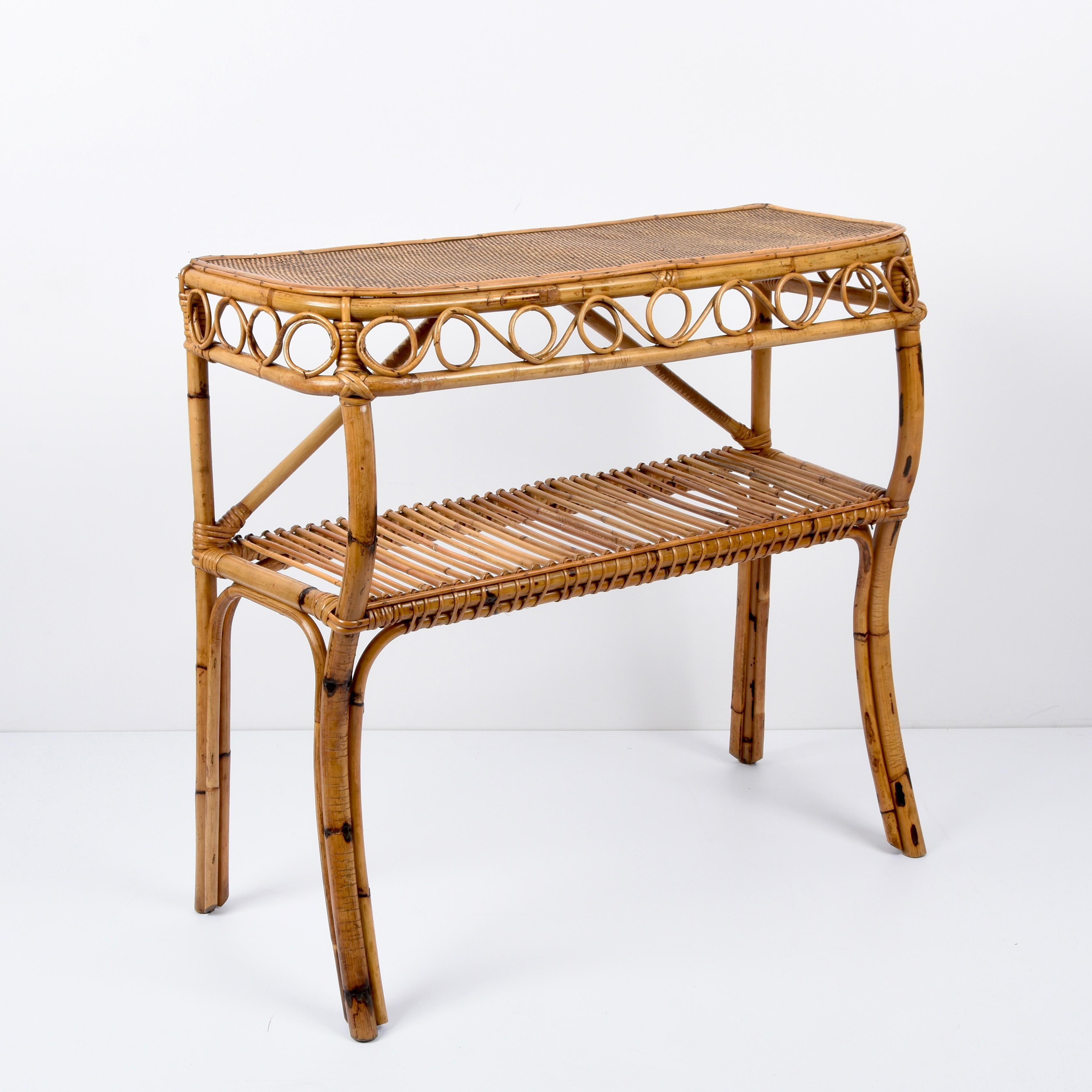 Wonderful console table in bamboo and rattan. This piece was produced in the style of Franco Albini in Italy during the 1970s.

This console has four bamboo legs, with a shelf in the middle of the structure featuring a rattan decoration.

A