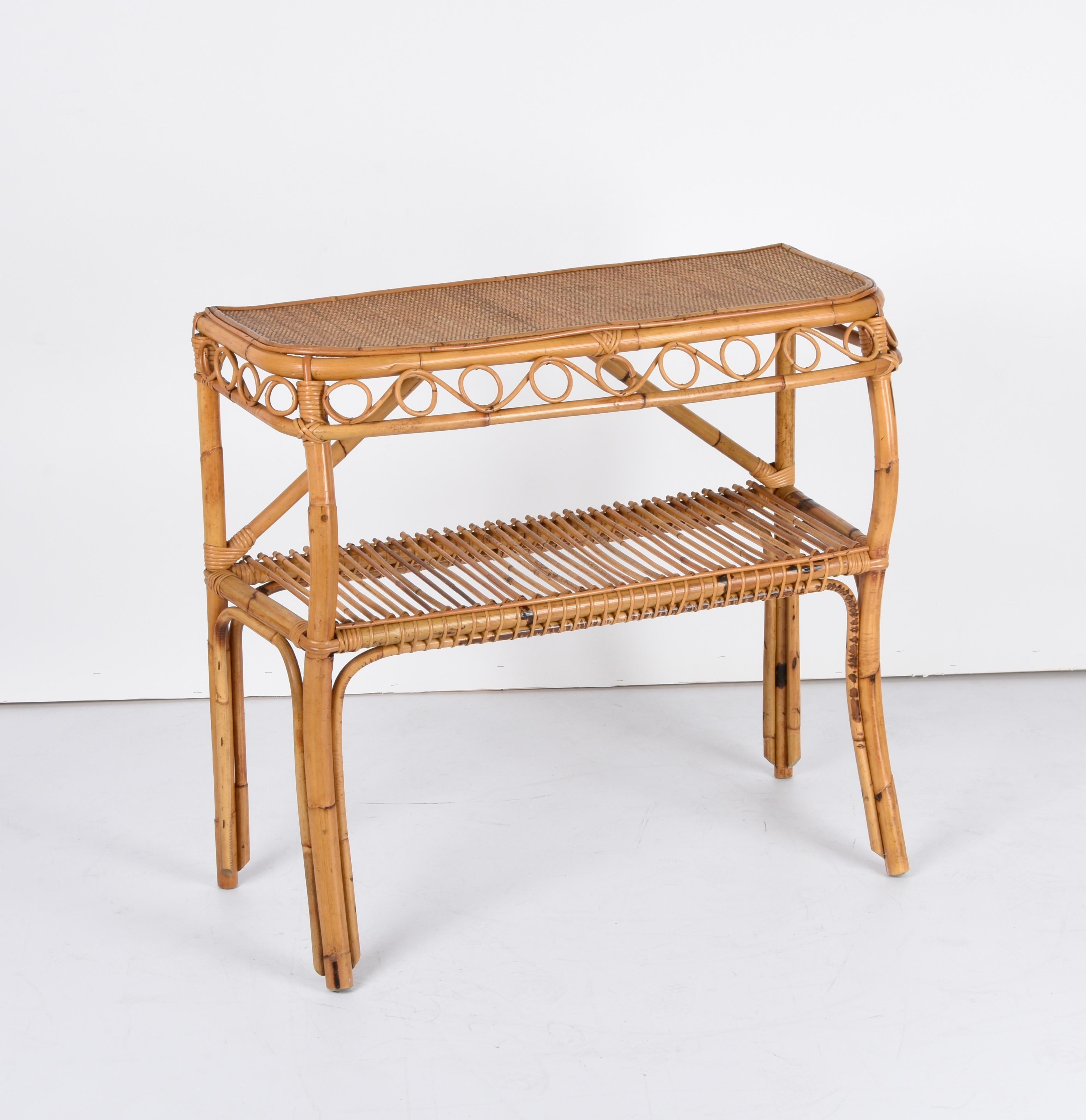 Stunning console table in bamboo and rattan. This piece was produced in the style of Franco Albini in Italy during the 1970s.

This console has four bamboo legs, with a shelf in the middle of the structure featuring a rattan decoration.

A