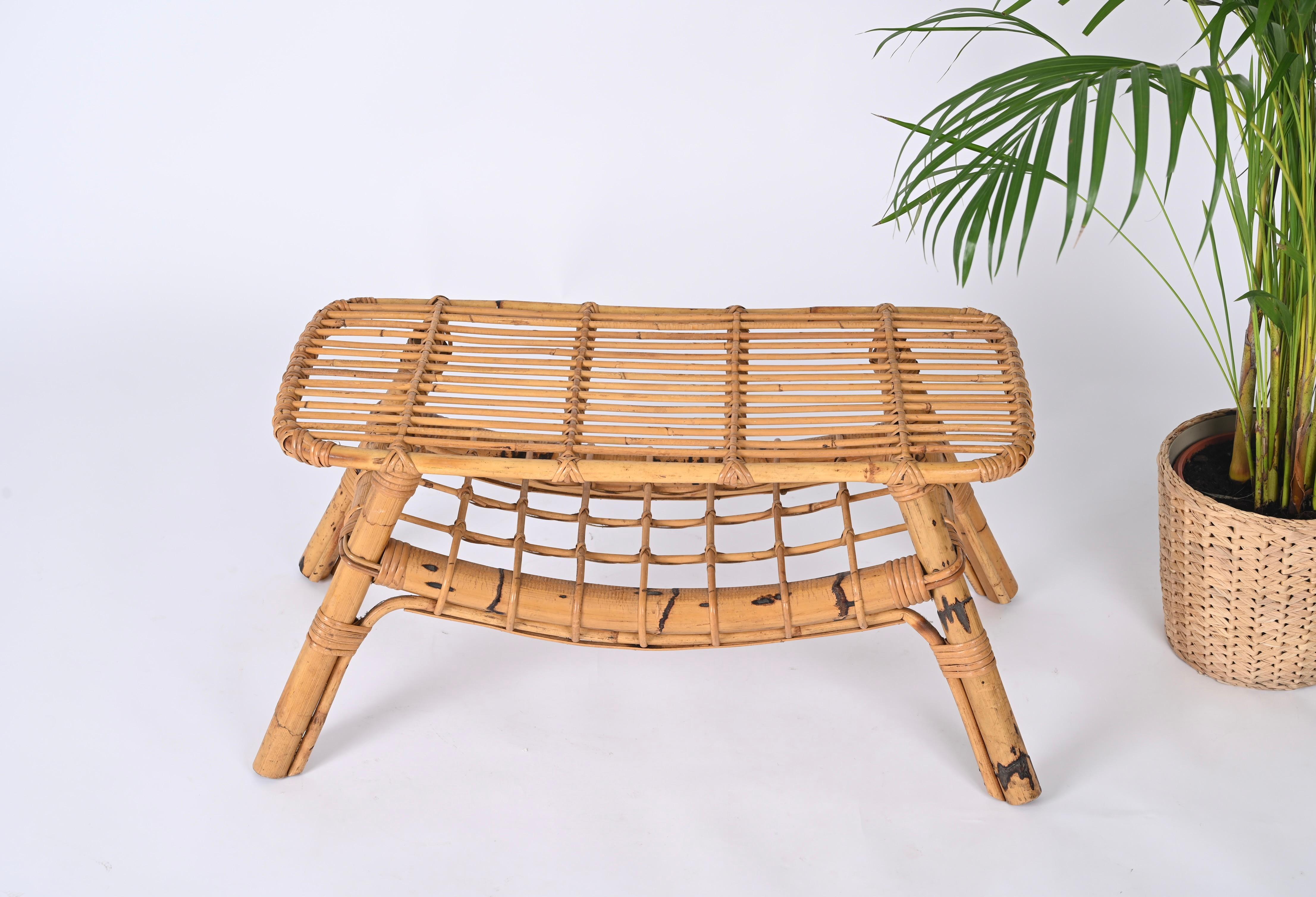 Fantastic midcentury Italian coffee table in bamboo and rattan. This gorgeous piece was designed in Italy during the 1960s and is attributed to Tito Agnoli. 

This coffee table of exceptional craftsmanship features a sturdy structure in curved