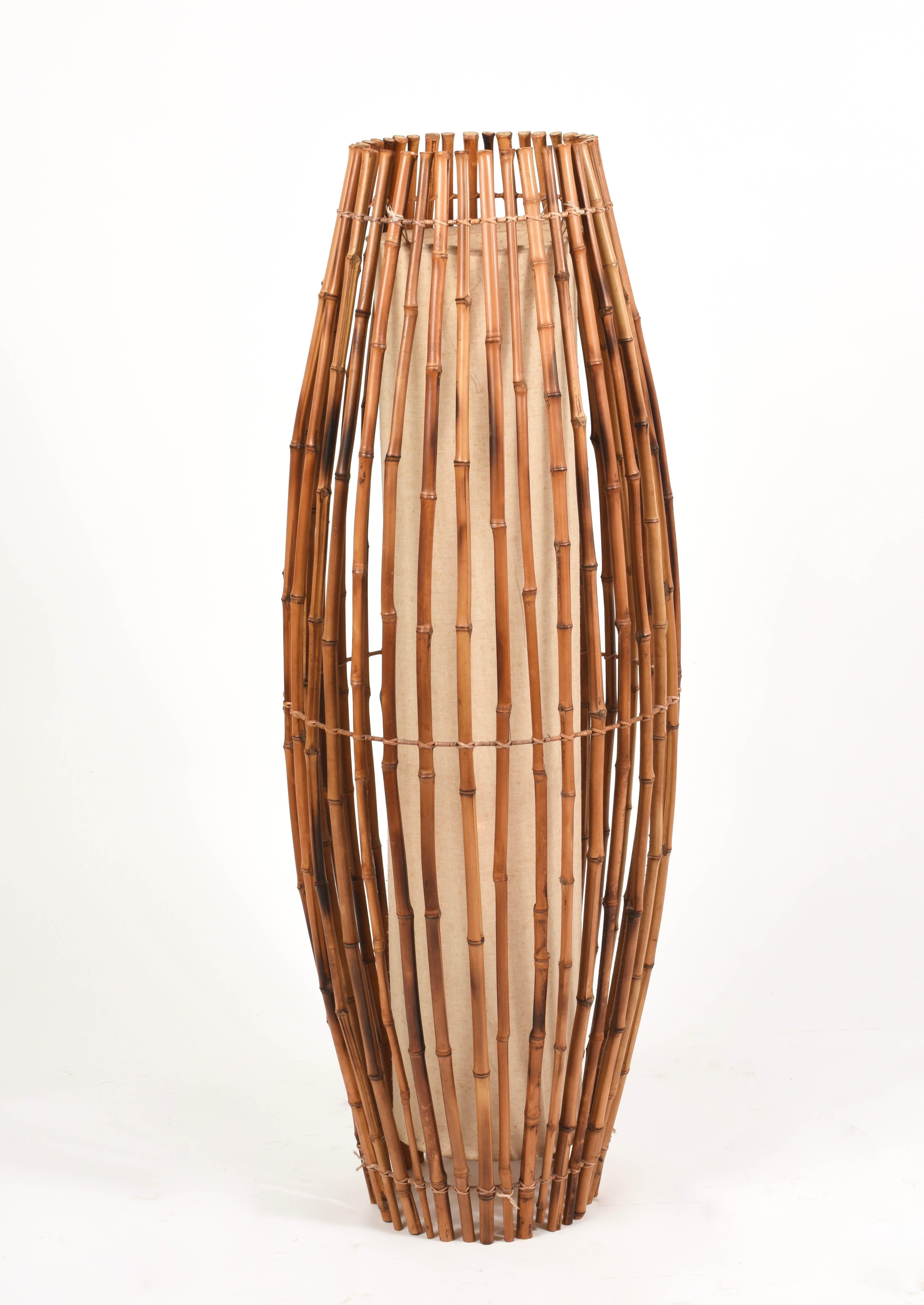 Wonderful midcentury floor lamp in the style of Franco Albini. It is a marvelous piece produced in Italy during 1960s.

It is made of bamboo and rattan and it has the shape of two cones narrowing in the centre.

This item is perfect for a