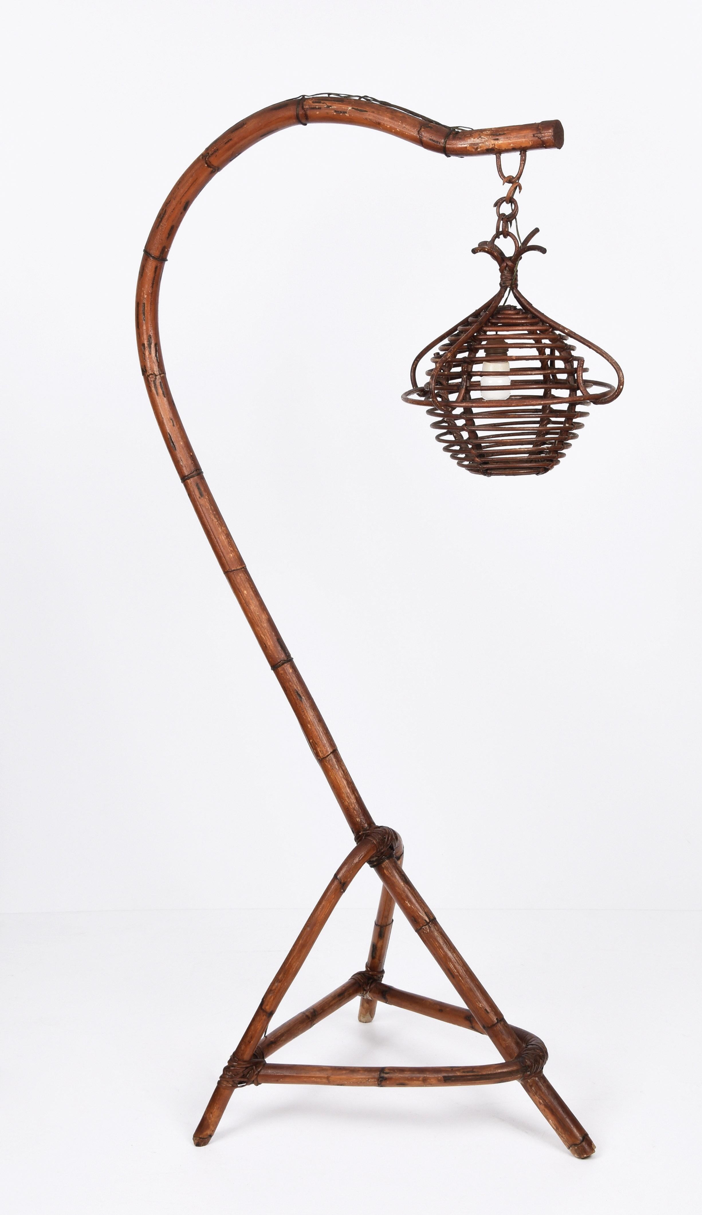 Amazing midcentury modern bamboo and rattan Floor Lamp. This fantastic item was produced in Italy during the1950s.

This piece is astonishing because of the fantastic three feet base and the arched structure. The rattan lampshade covering the