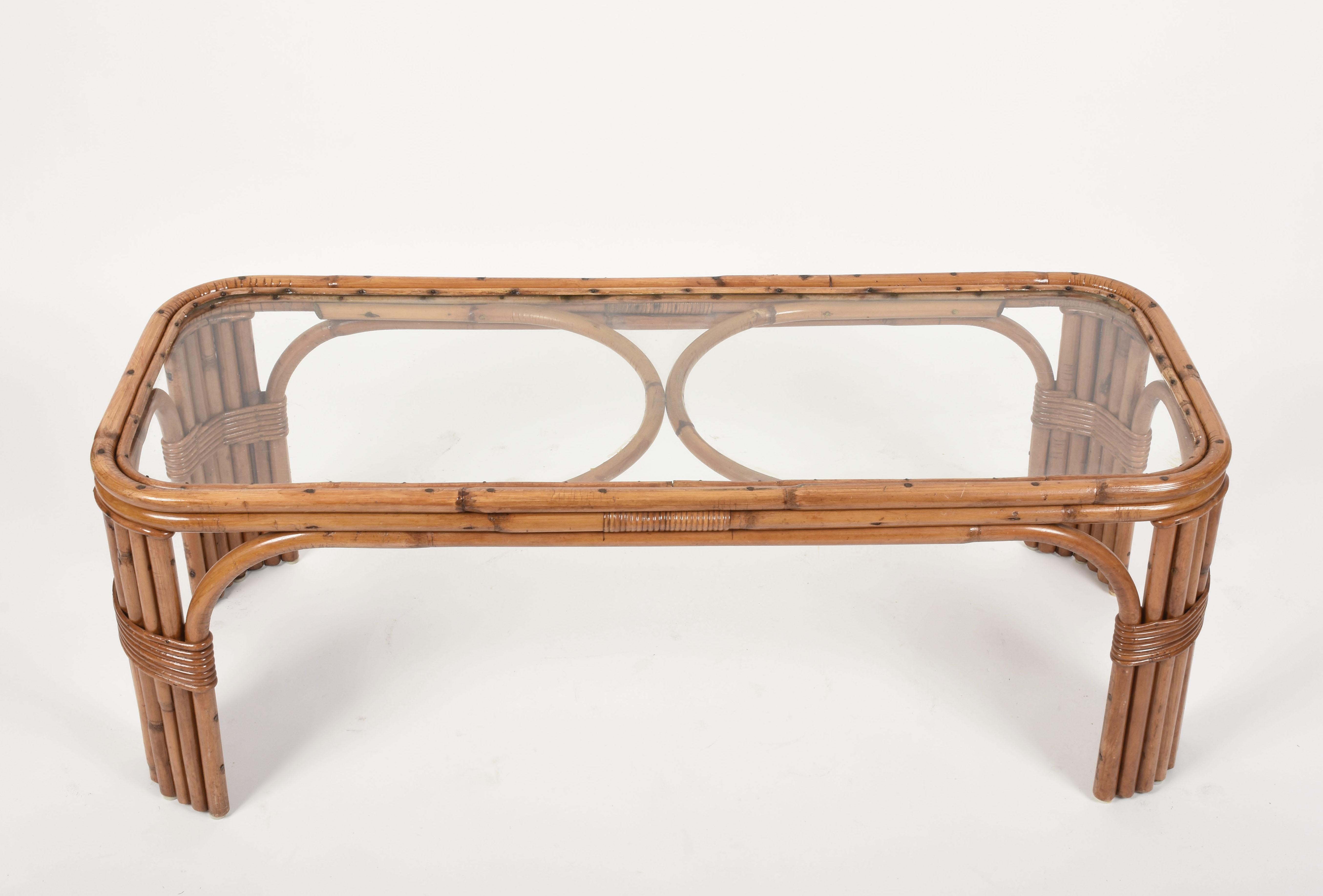 Elegant midcentury rectangular bamboo coffee table with rattan finishes and smoked glass top.

This iconic Italian piece is attributed to the designer Tito Agnoli and the production of Bonacina and it is dated in between the 1960s.

The delicate