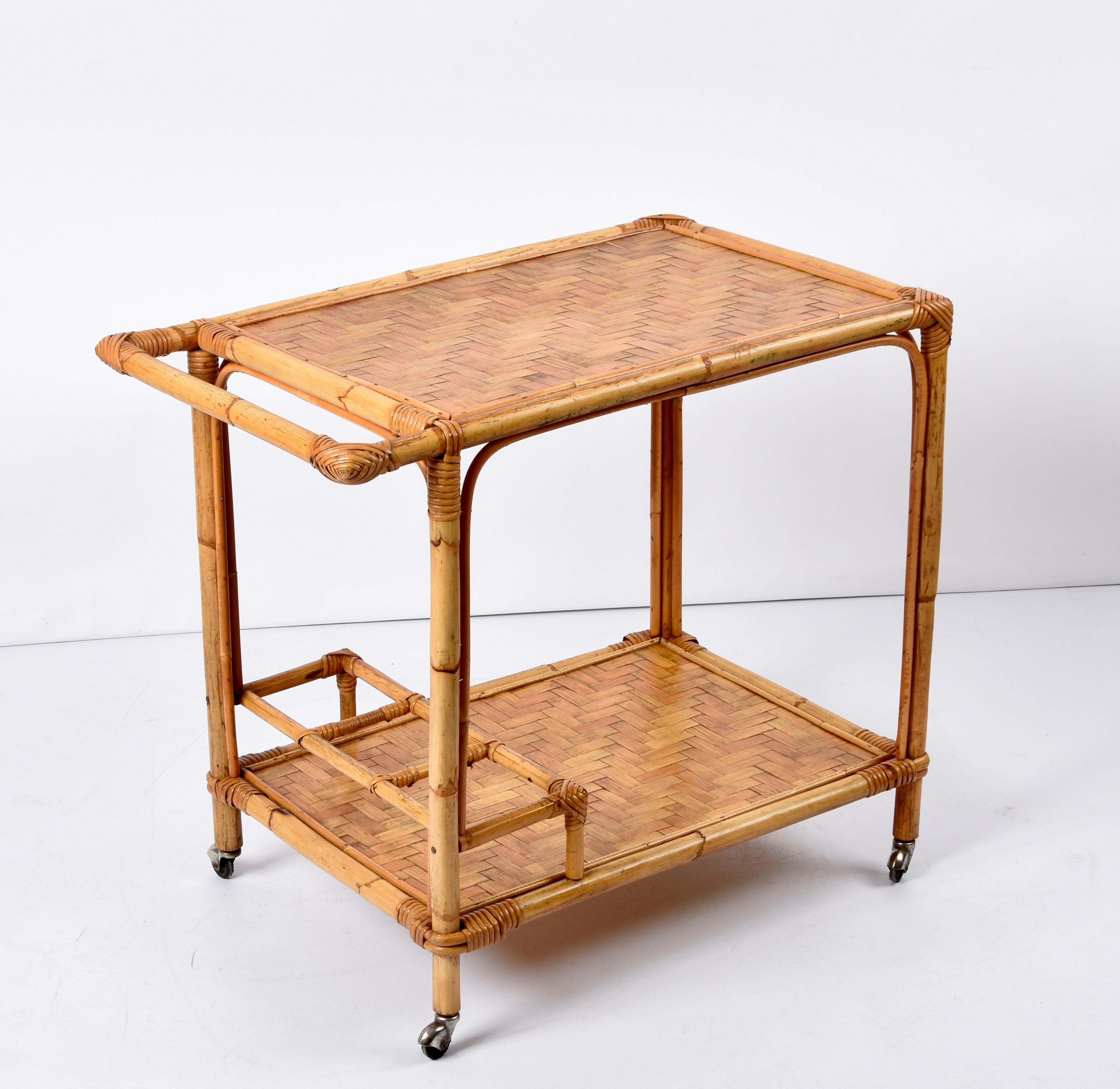 Midcentury bamboo cane and rattan rectangular bar cart trolley with wheels. This unique piece was produced in Italy during the 1960s.

A wonderful item in a fantastic vintage condition, with four small wheels and two squared bottle holders within