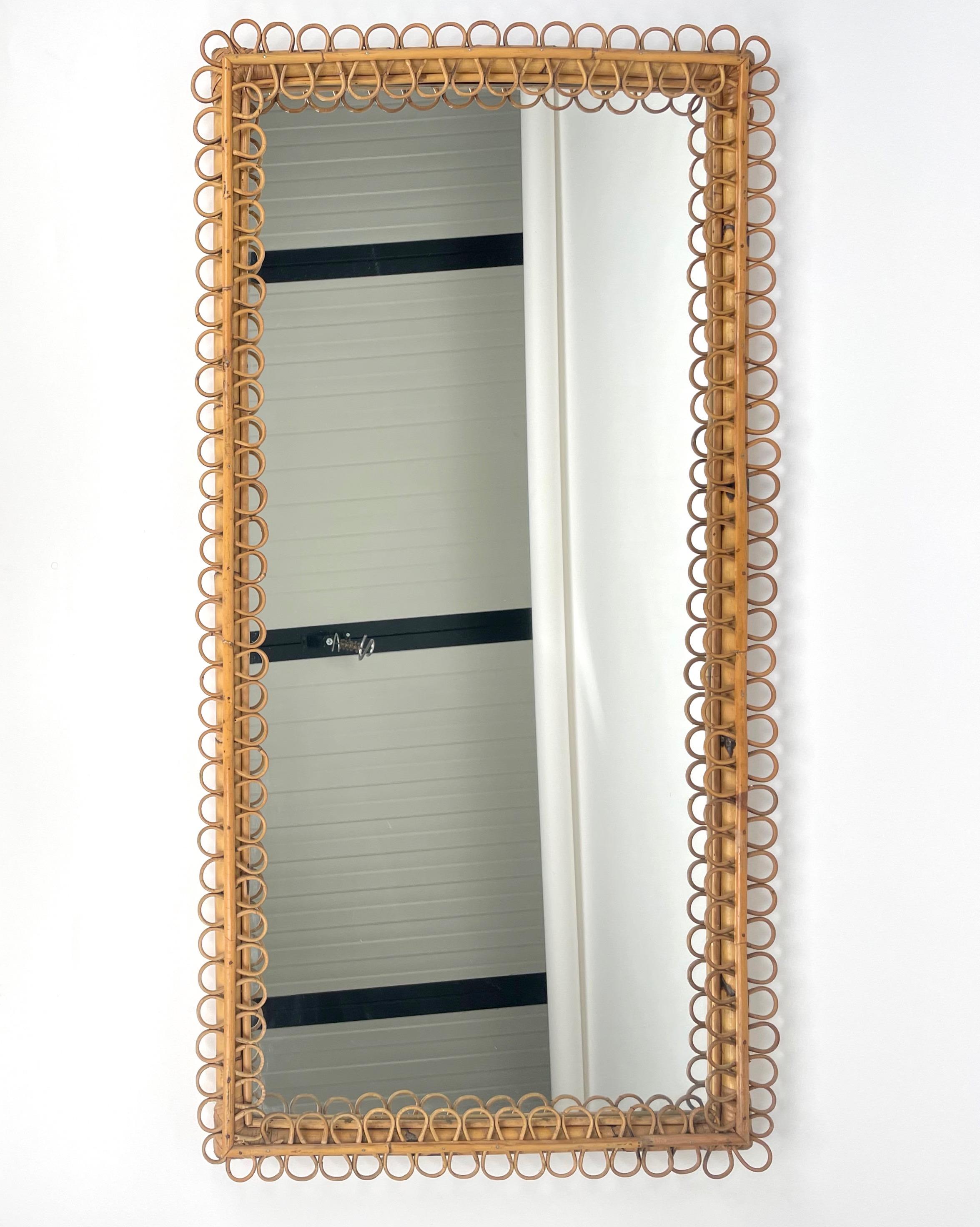 Rare and large rectangular wall mirror in a bamboo frame adorned by rattan curlicues. 

Made in Italy in the 1960s.