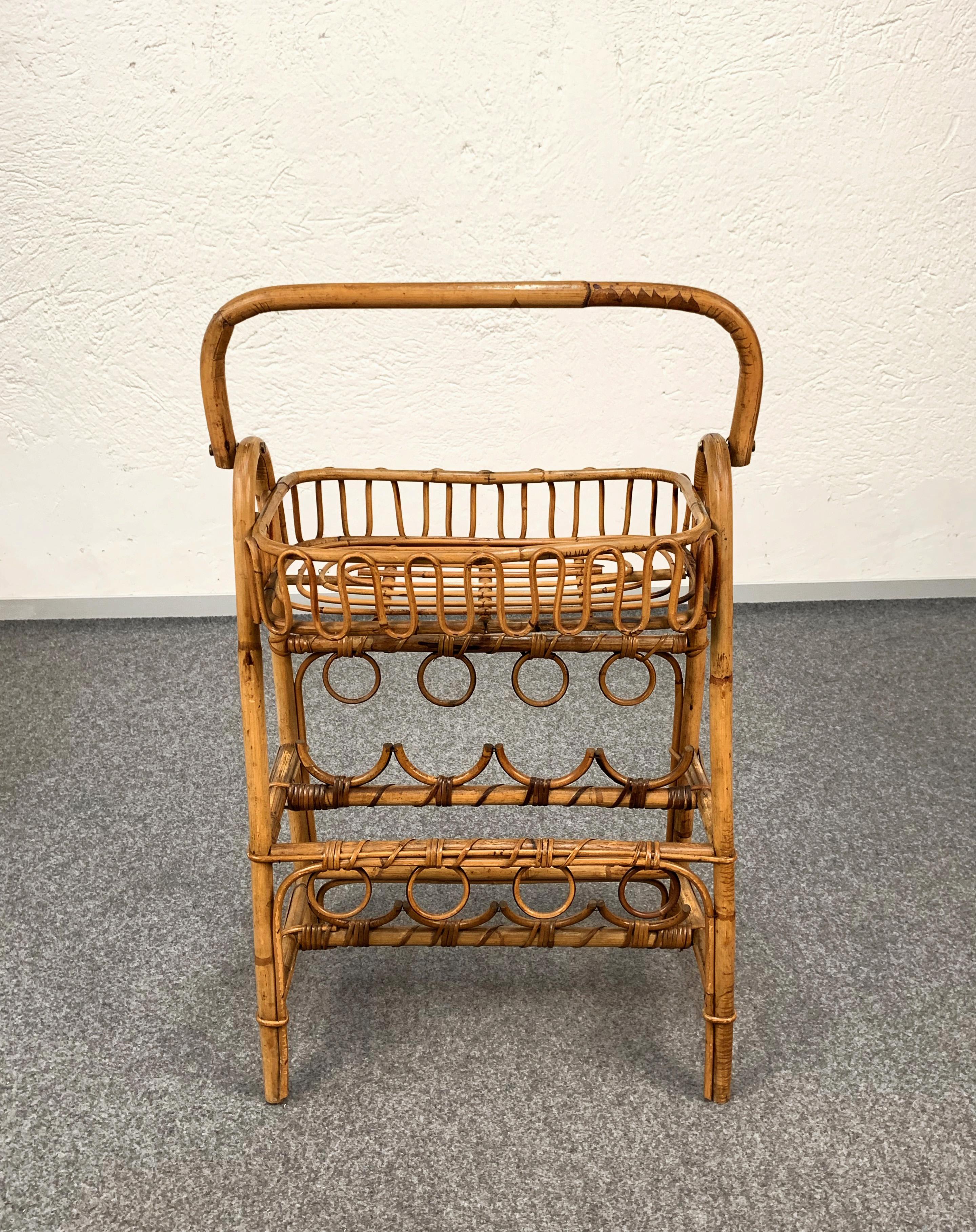 A very elegant and beautiful service table with bottle holder. This item is made of bamboo and rattan and has two floors, the top one it's a side table while the lower one is a bottle holder. 

It is a midcentury Italian production from the 1960s.