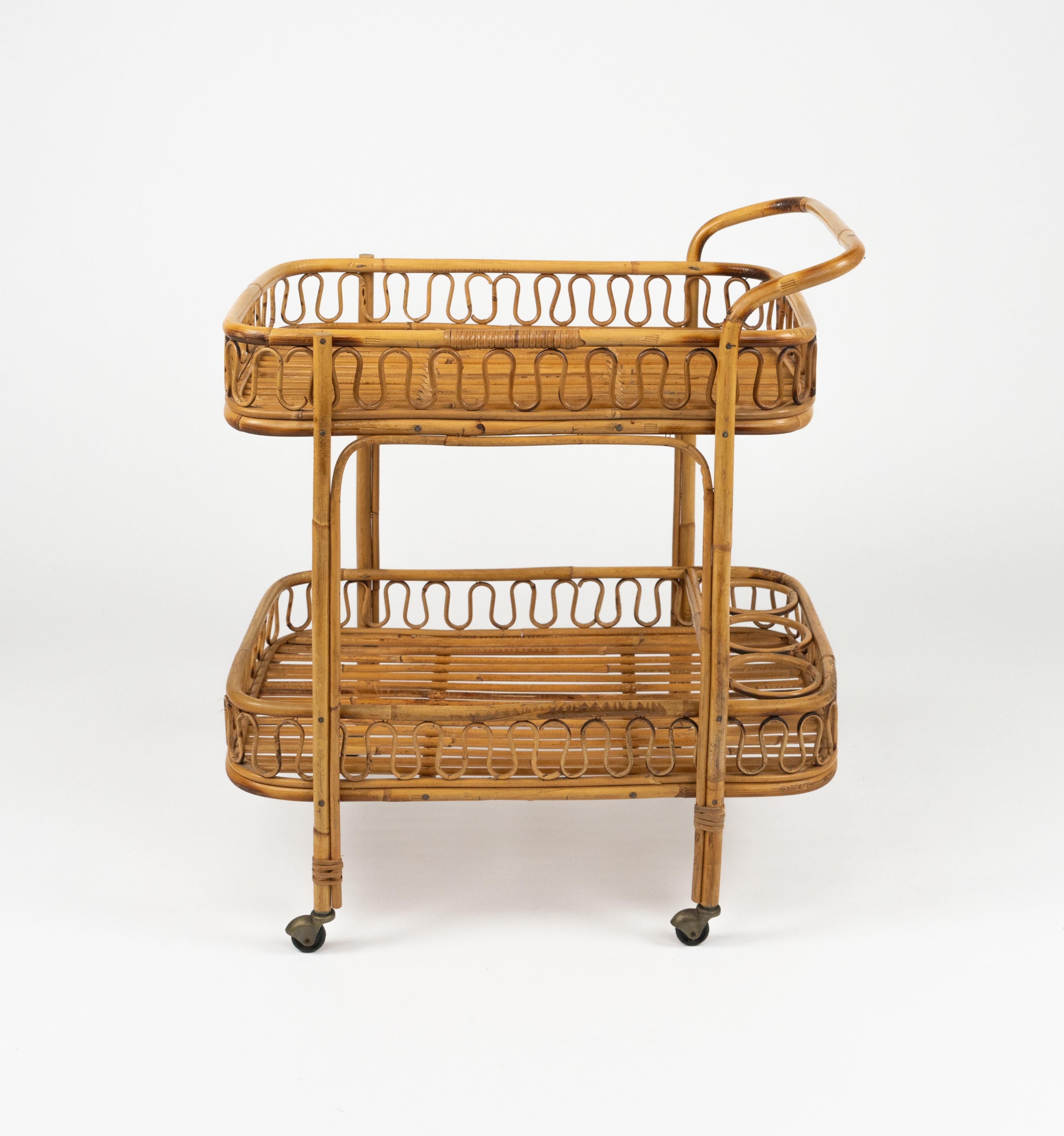 Midcentury wonderful serving bar cart in bamboo, rattan and wicker with three bottle holder in the style of Franco Albini.

Made in Italy in the 1960s.