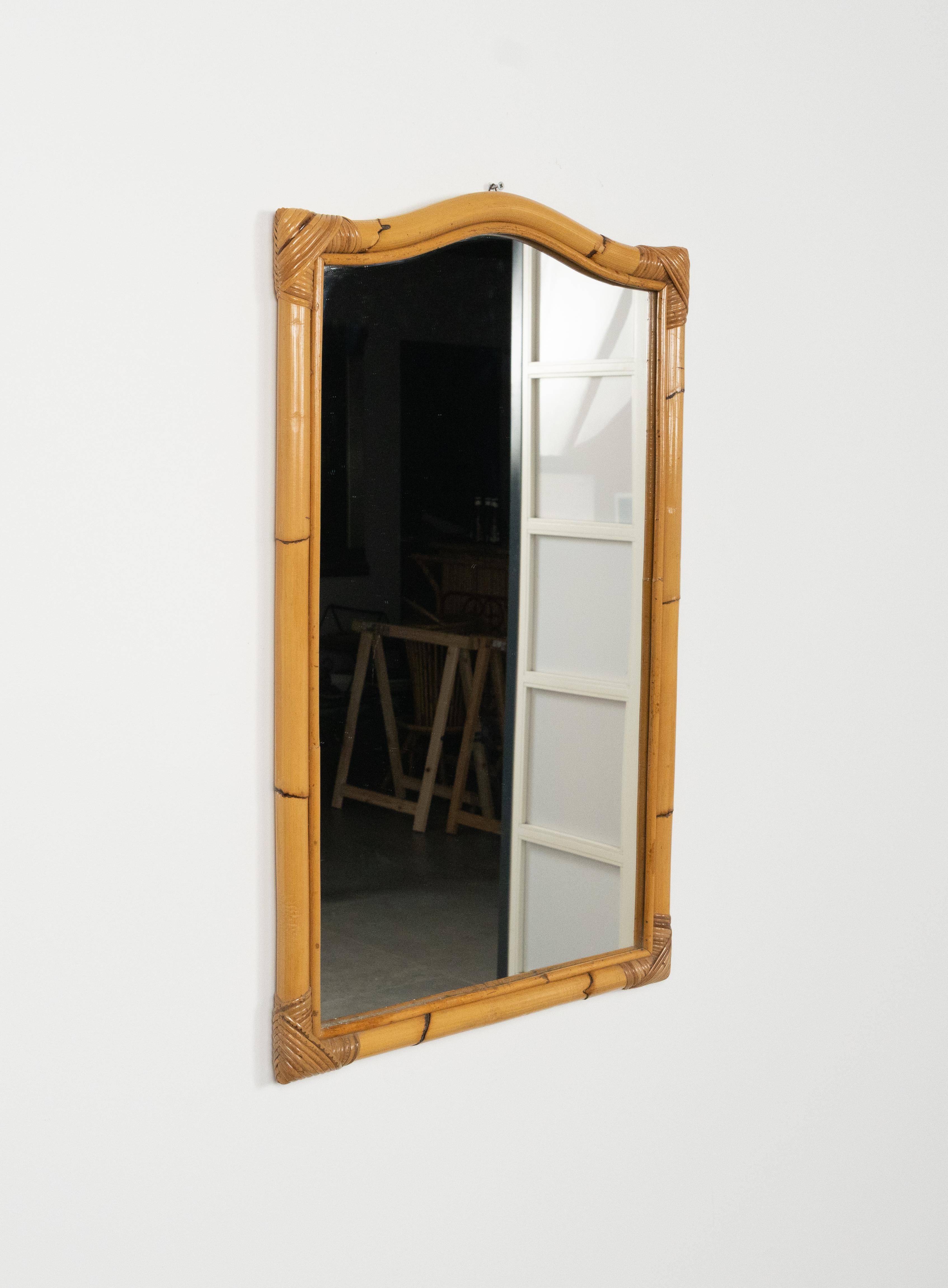 Bellissimo specchio da parete del Medioevo in rattan e bambù.

Realizzato in Italia negli anni '70.

La cornice presenta un design leggermente curvo nella parte superiore, dando un tocco decorativo e armonioso alla forma rettangolare dello