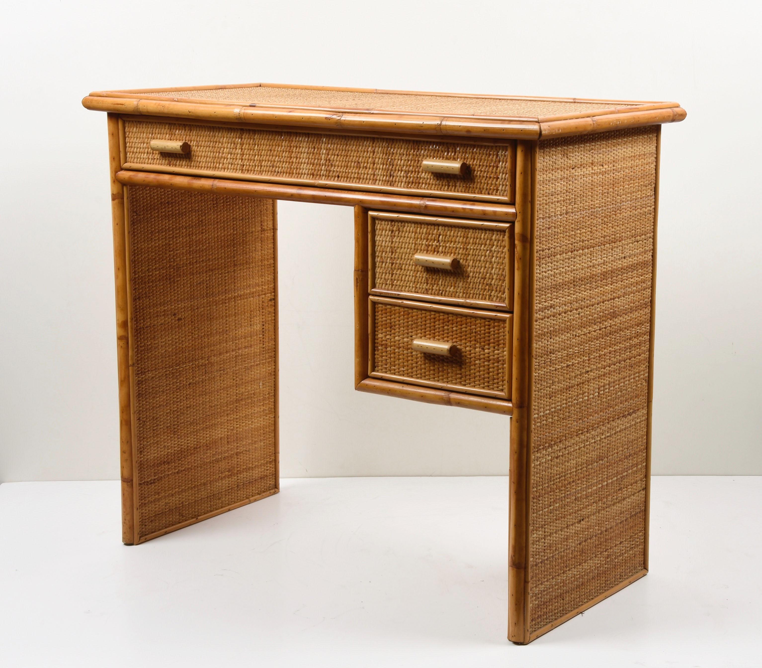 Amazing midcentury bamboo and wicker desk with drawers. This wonderful piece was designed in Italy during the 1980s.

This writing table is unique because of the materials used, bamboo and rattan, and it has three drawers, a large one and two