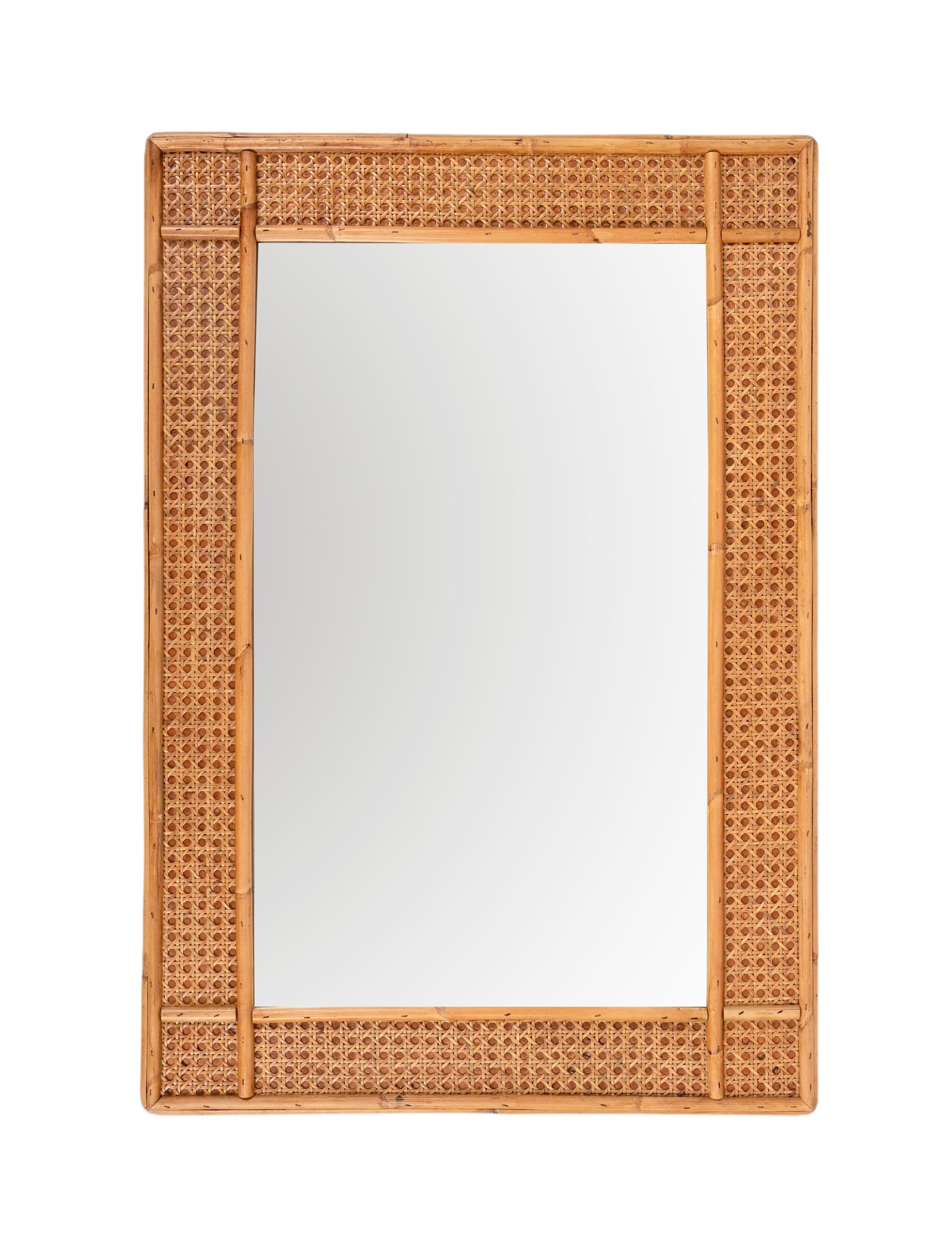 Spectacular midcentury rectangular bamboo and woven wicker mirror. This outstanding item was produced in Italy during the 1970s.

This piece is incredible thanks to its complex frame: it has an internal part made of a single bamboo cane, the