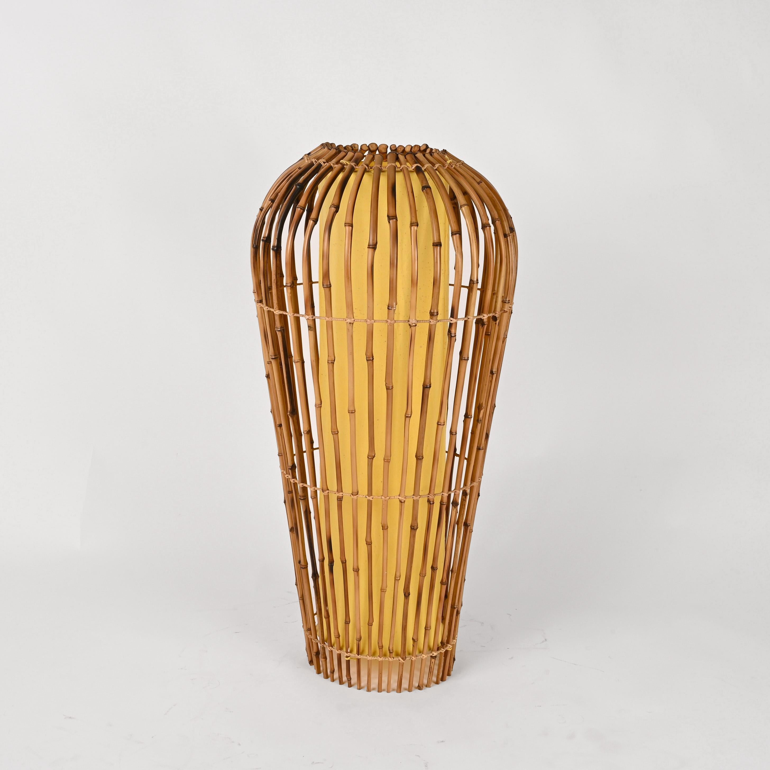 Wonderful midcentury bamboo canes and rattan floor lamp. This amazing piece was designed in Italy during the 1970s after Franco Albini.

This item is unique has it has an original shape with a narrow base that gets wider and wider to the top with