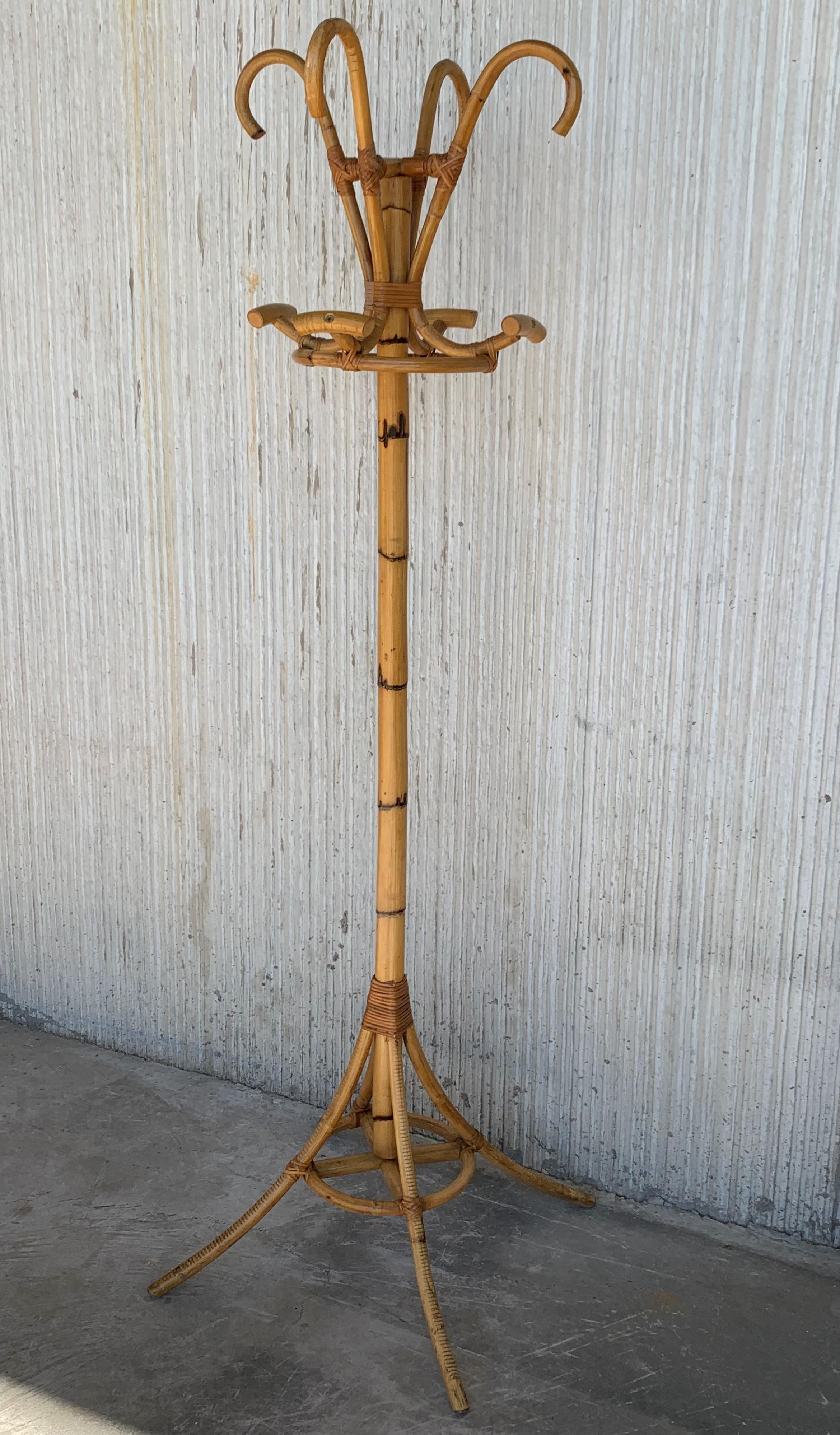 Fun and quirky vintage coat rack or stand made from stained bamboo. Four double hooks serve as coat or hat hooks. Central rod is stabilized at floor with four legs and decorative ring.