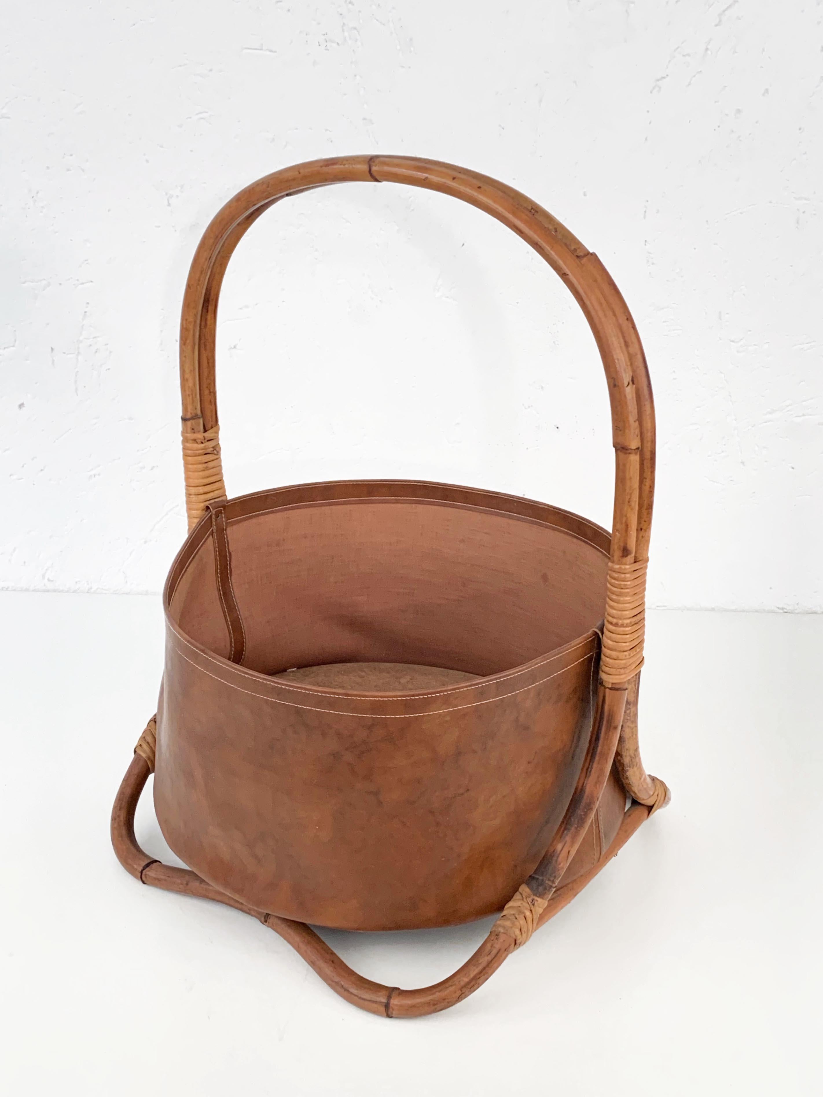 Incredibile portariviste di metà secolo in bambù, rattan e pelle. Questo pezzo unico è stato prodotto negli anni '70 nello stile di Jacques Adnet.

Un accessorio di lusso per qualsiasi ambiente o ufficio moderno, in quanto l'oggetto non è troppo