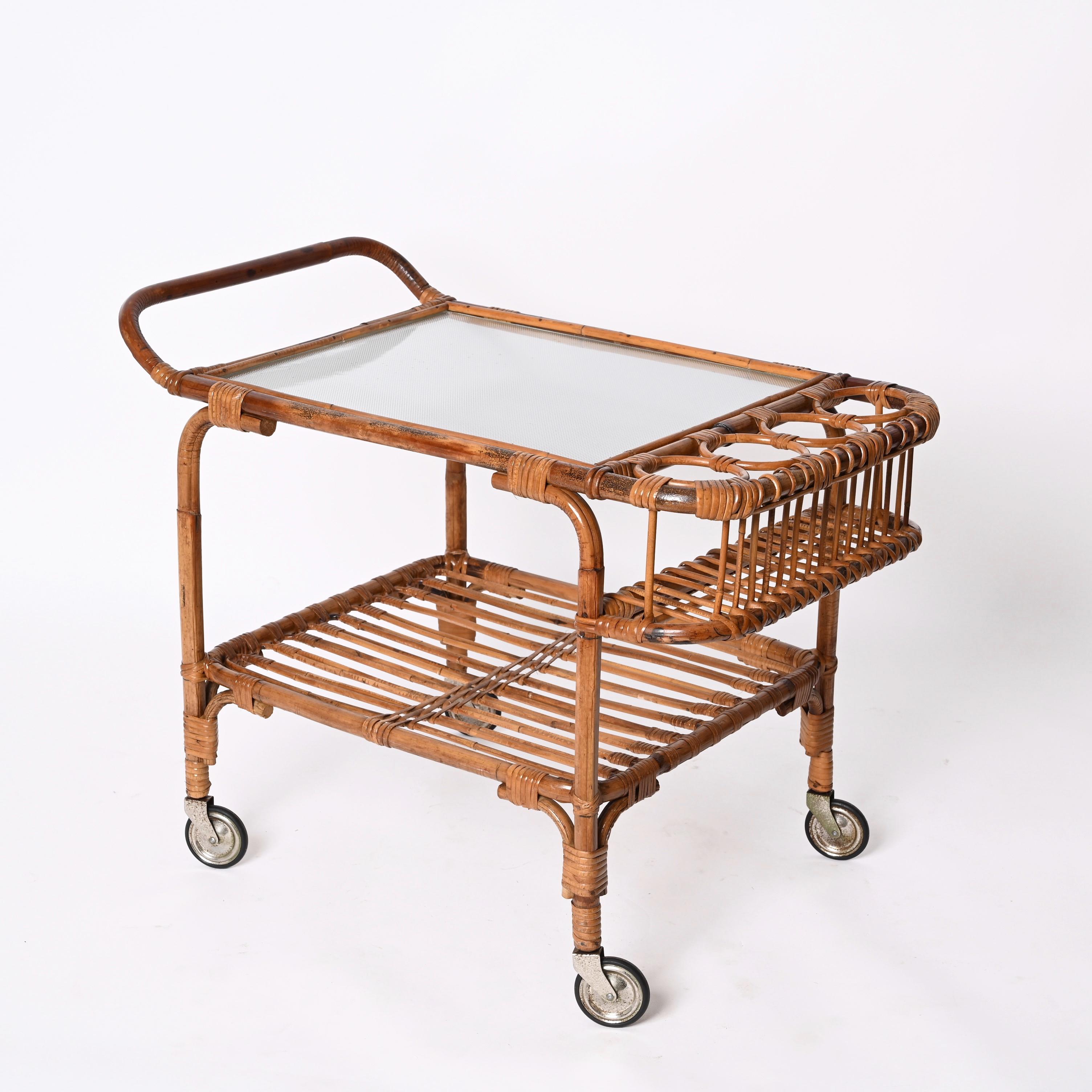 Stunning midcentury bamboo cane and rattan rectangular bar cart trolley with the top in glass and metal wheels. This unique piece was produced in Italy during the 1960s.

A wonderful piece in a fantastic vintage condition, with four bottle holders