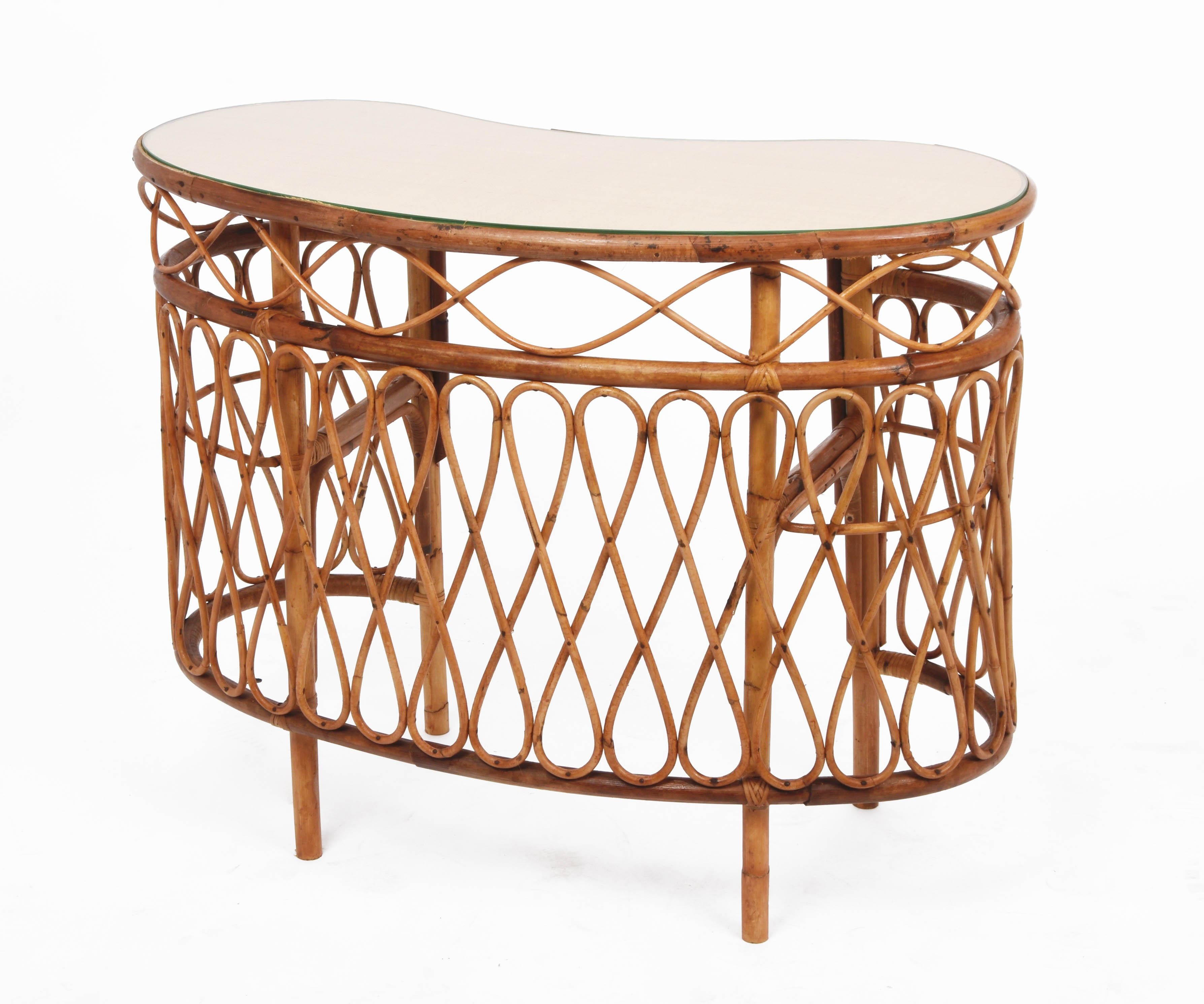 Eye-catching bean-shaped console in bamboo and rattan with glass top and two internal crescent glass shelves. This piece was produced following the style of Franco Albini in Italy during the 1970s.

This fantastic console table has four bamboo