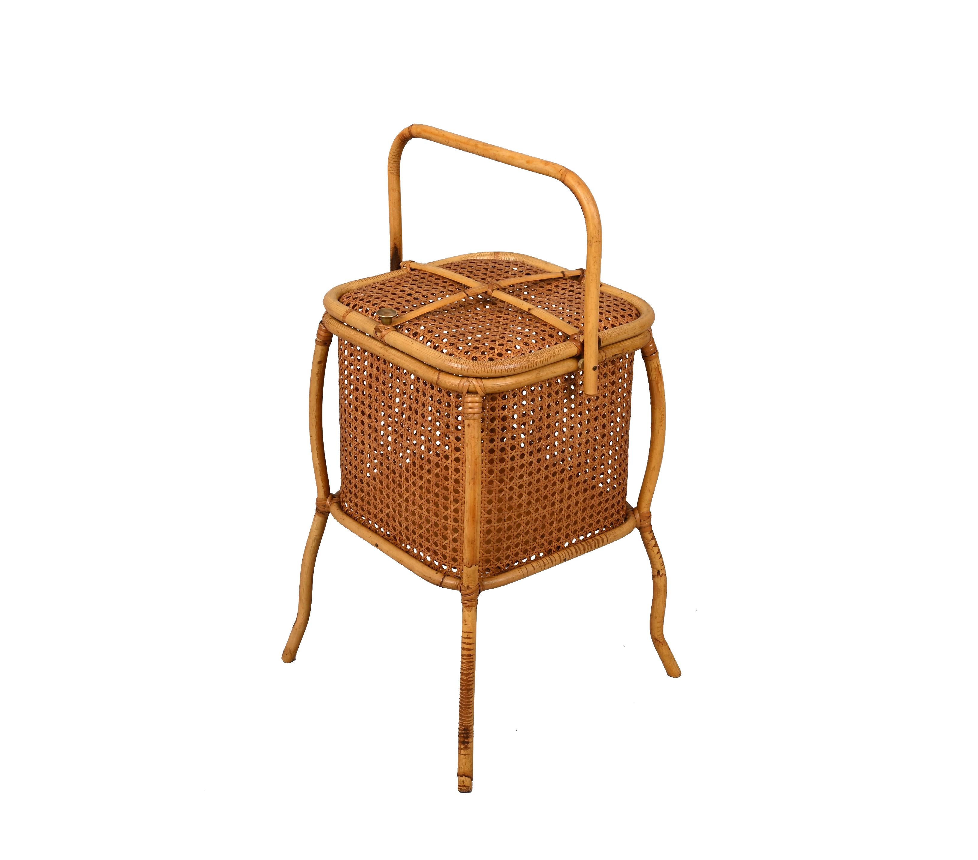 Unique midcentury magazine rack in bamboo cane, Vienna straw and rattan with a brass knob. This fantastic piece was made in Italy during the 1960s.

This astonishing item is fantastic as the shape of the item is cubic, with a handler made of a