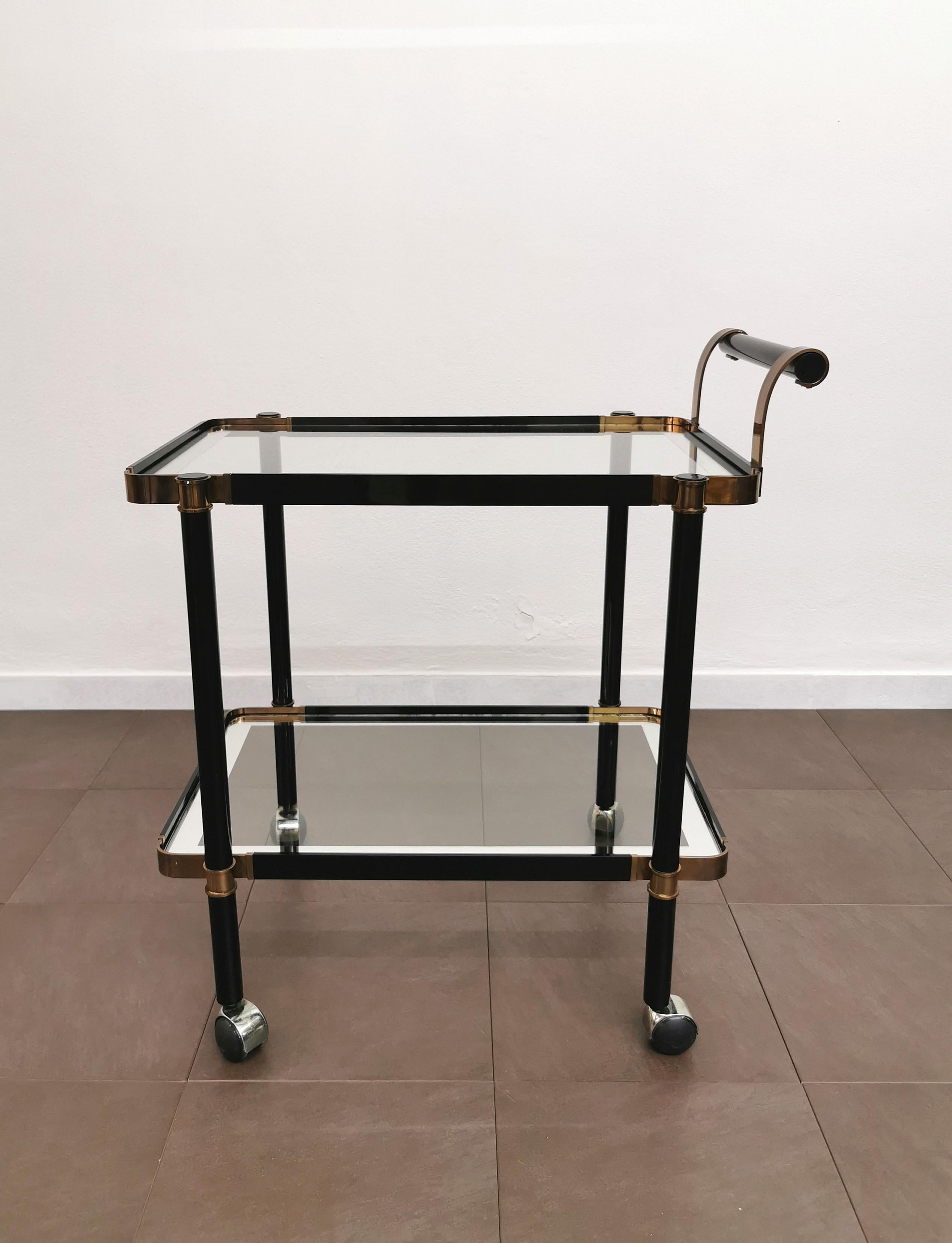 Fine and elegant bar cart produced in Italy in the 70s of excellent manufacture. The bar cart was made with a black and brass enamelled aluminum structure and 2 glass lunch box shelves with mirrored glass border.



Note: We try to offer our