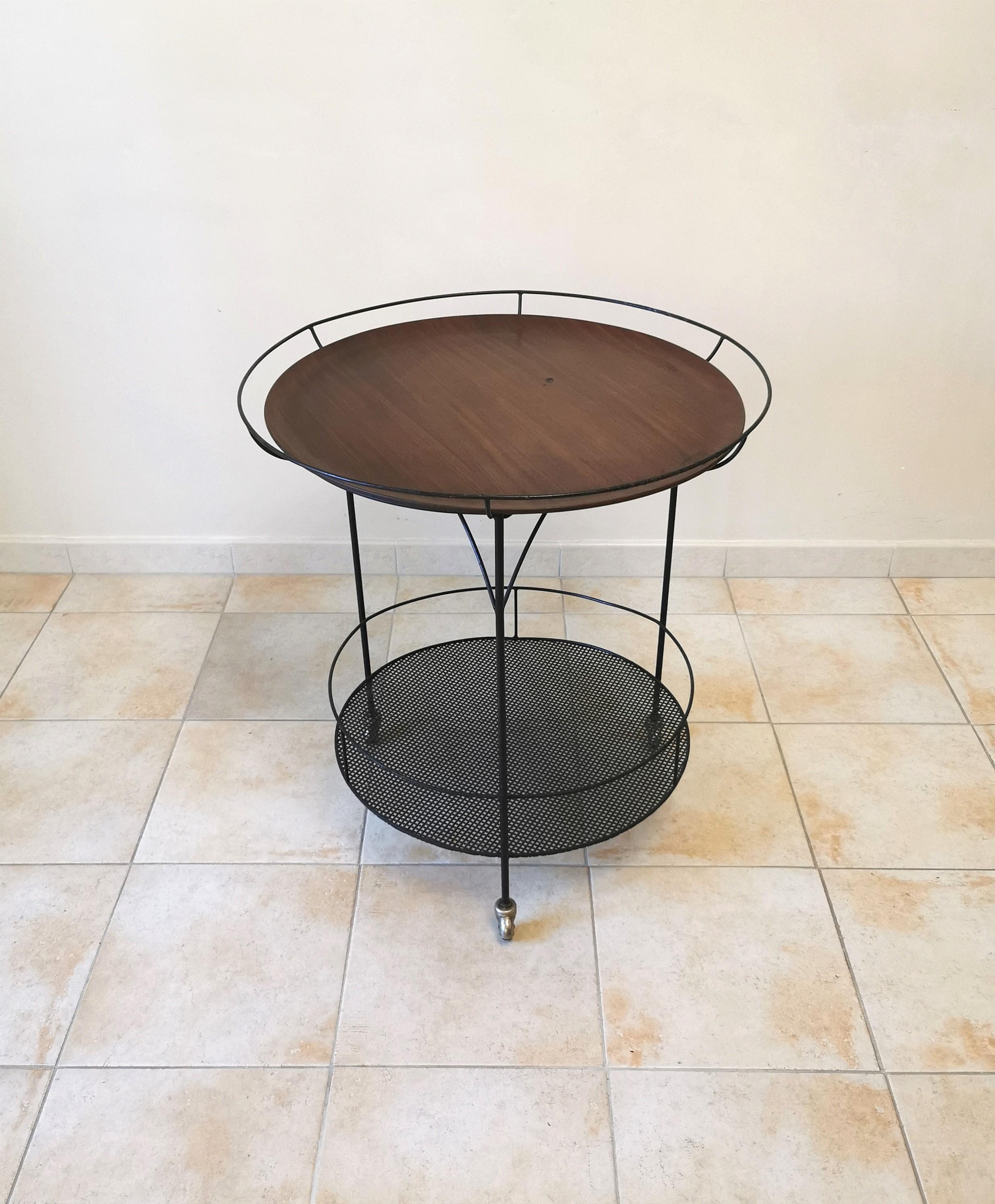 Bar cart/food holder on wheels made in Italy in the 60s. The bar cart has a black enamelled metal structure with a perforated lower shelf and a removable circular wooden shelf.



Note: We try to offer our customers an excellent service even in