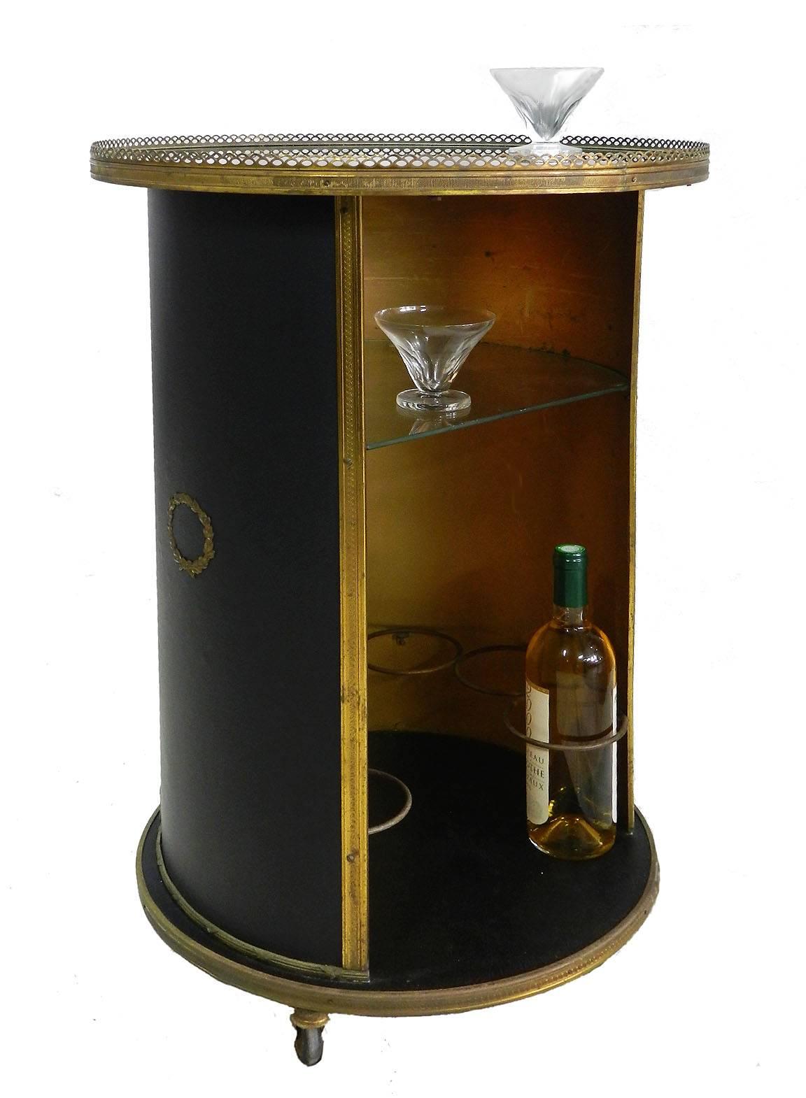 Midcentury bar cart Hollywood Regency cocktail trolley in the manner of Jansen
Rare find very unusual
Circular top round with brass gallery and high shine inset top
Covered in thin black faux leather with ormolu wreath mounts
Black and gold.
In very