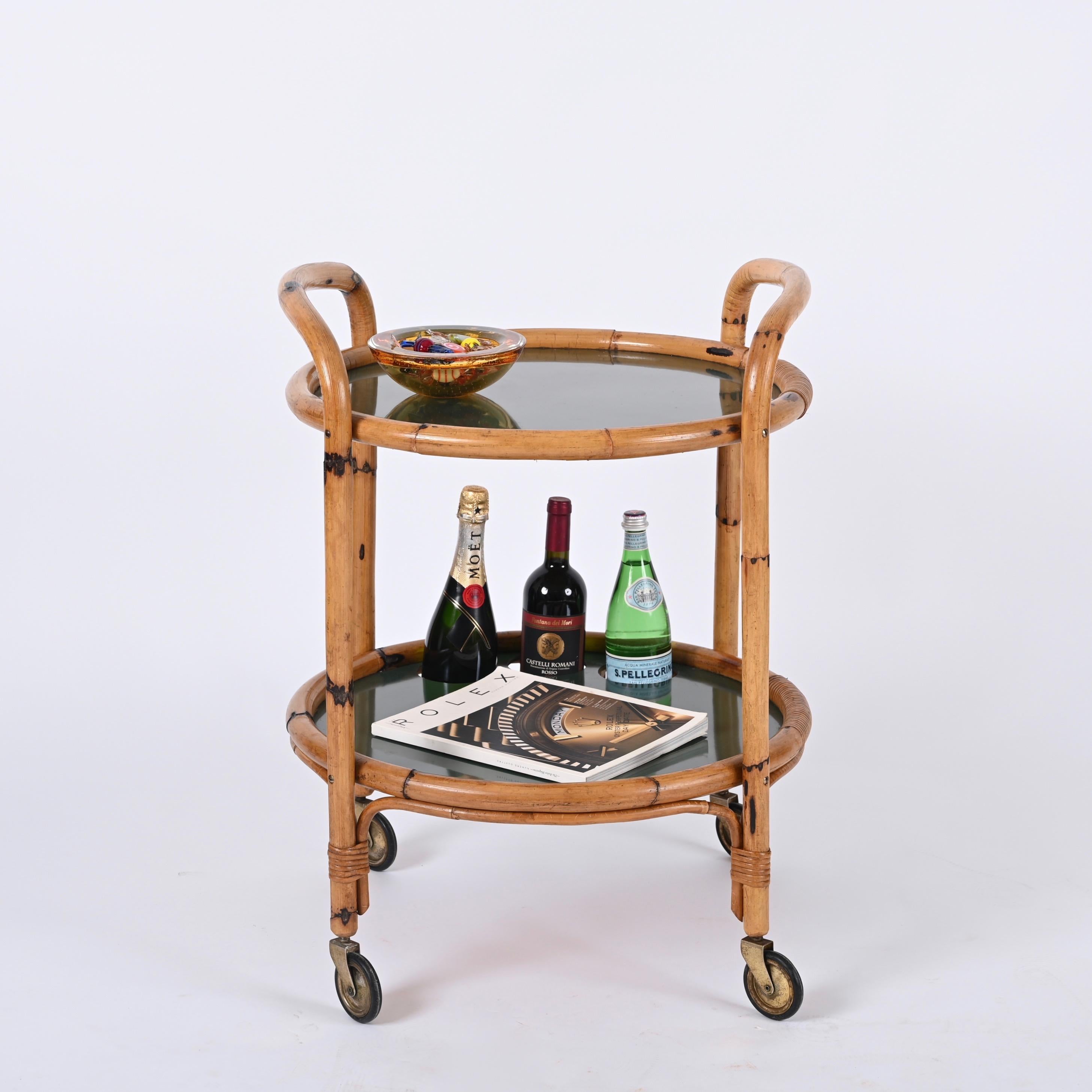 Stunning midcentury round serving cart in bamboo, rattan and green formica. This unique piece was produced in Italy in the 1970s.

The bar cart features a beautiful structure made in curved bamboo with curved handles and two levels in a charming