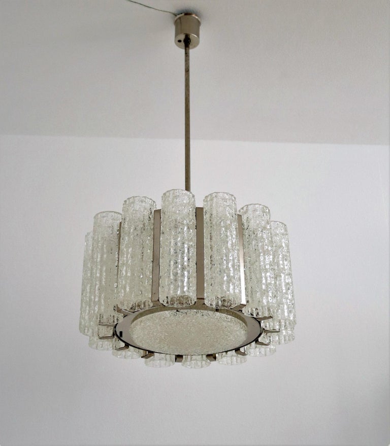 Italian midcentury chandelier with 14 ice glass tubes, 1 big ice glass plate and a lamp frame made of chromed steel with original vintage patina and light spots.
Made by Barovier e Toso in the 1960s.
The chandelier is in great vintage and working