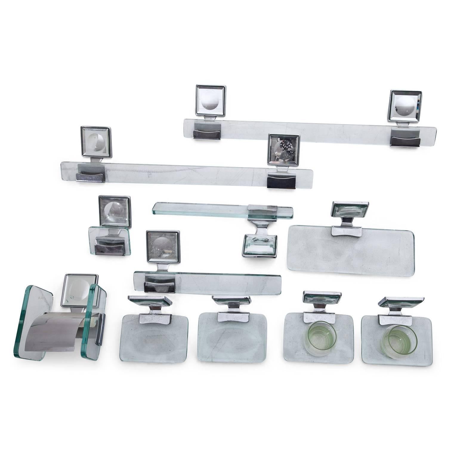 Set of eleven bathroom fixtures out of glass and chrome with mirrored mounts (8 x 8 x 1 cm), consisting of tooth mugs, soap dishes, towel racks and toilet roll holder.