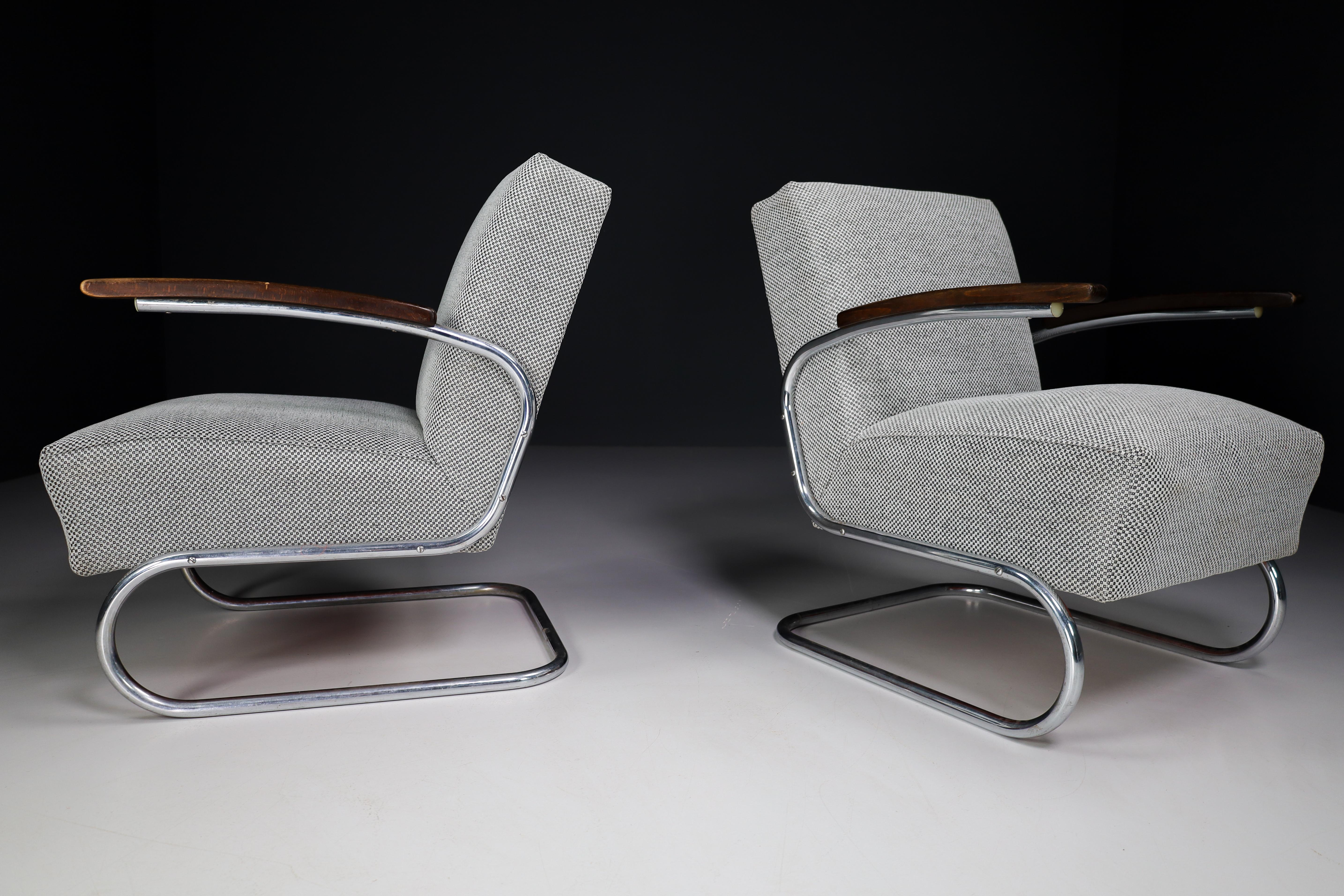 Model S411 armchairs by Thonet circa 1930s mid-century Bauhaus period. These cantilever armchairs are typical for the German and Eastern Europe Bauhaus era. These armchairs has a tubular steel frame and is re-upholstered with a grey fabric. The