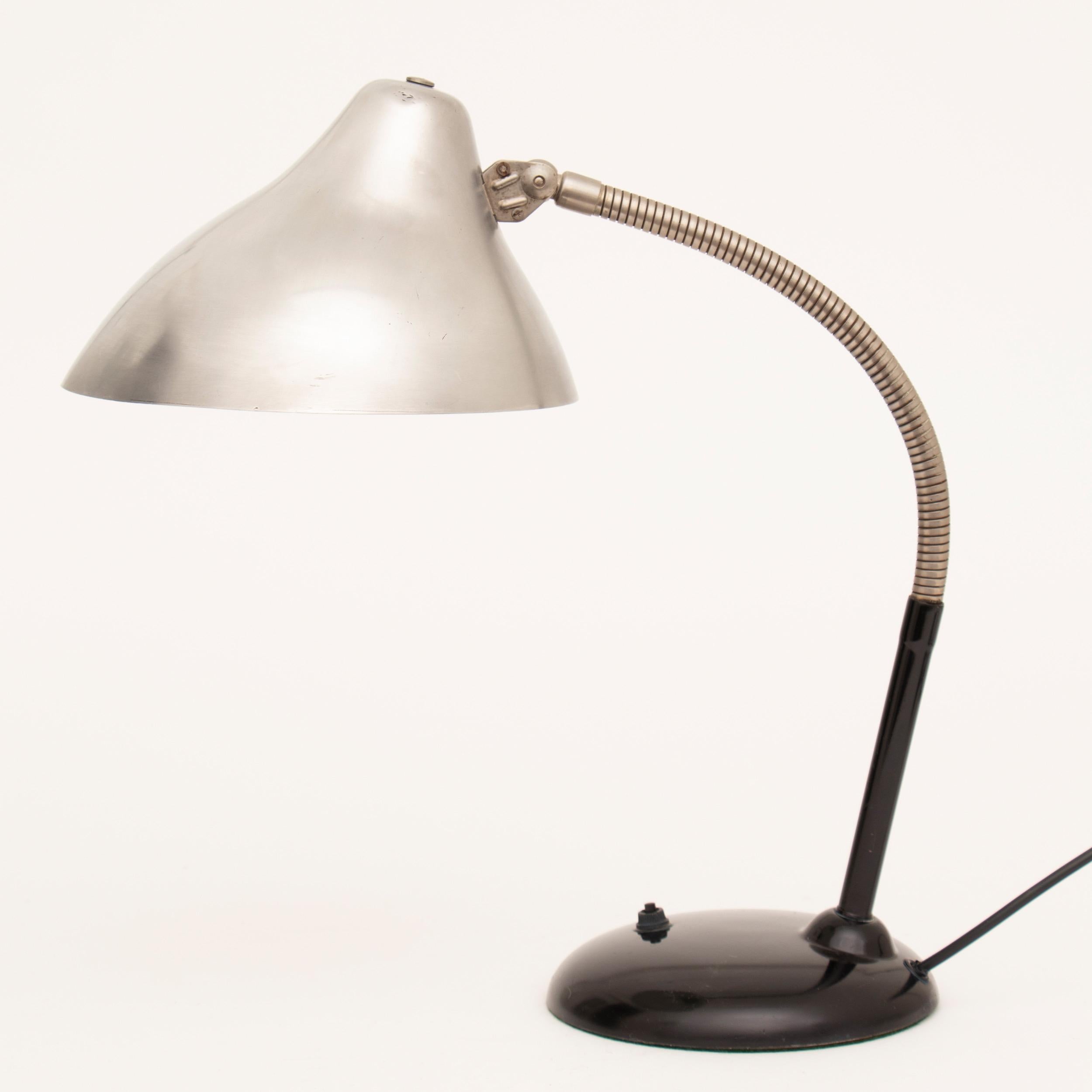 Midcentury desk or table lamp
Painted black metal base with flexible goose neck and piviting aluminium canopy shade
Measures: H 43cm, W 23cm, D 40cm
Germany, circa 1950.