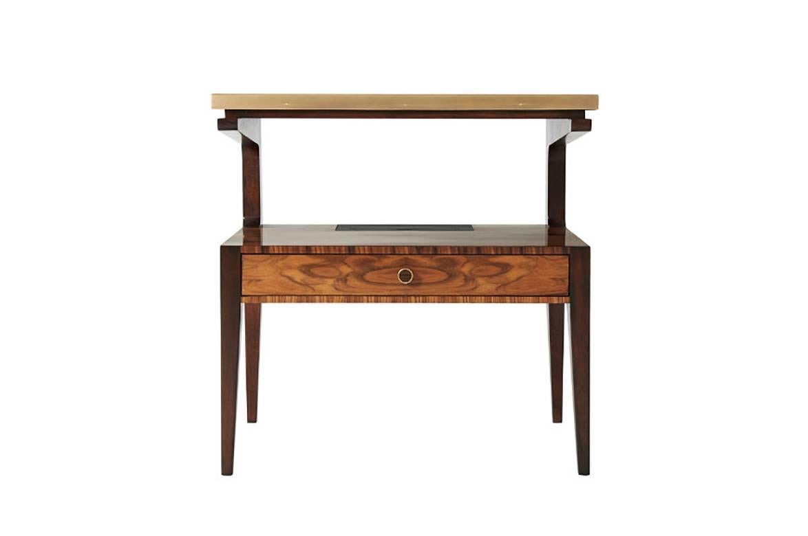 Table de chevet du milieu du siècle en palissandre sauvage et acajou, deux niveaux et un seul long tiroir, et une unité de charge en laiton.

Dimensions : 26