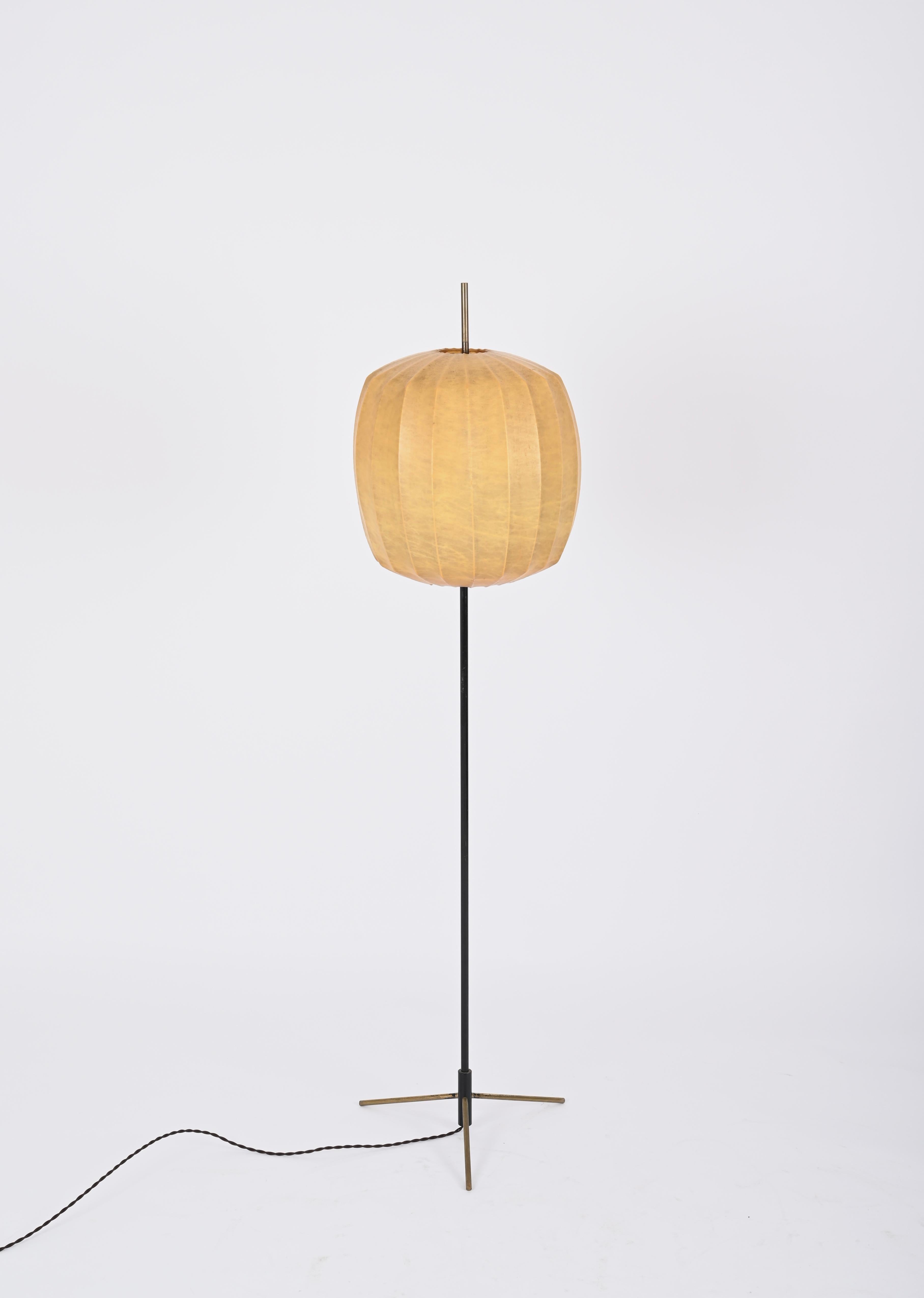 Stunning cocoon floor lamp designed by Achille Castiglioni in Italy in the 1960s. 

This breathaking floor cocoon lamp features a lovely structure in black enameled metal with the three feet and the top in solid brass. The cocoon shade has a round