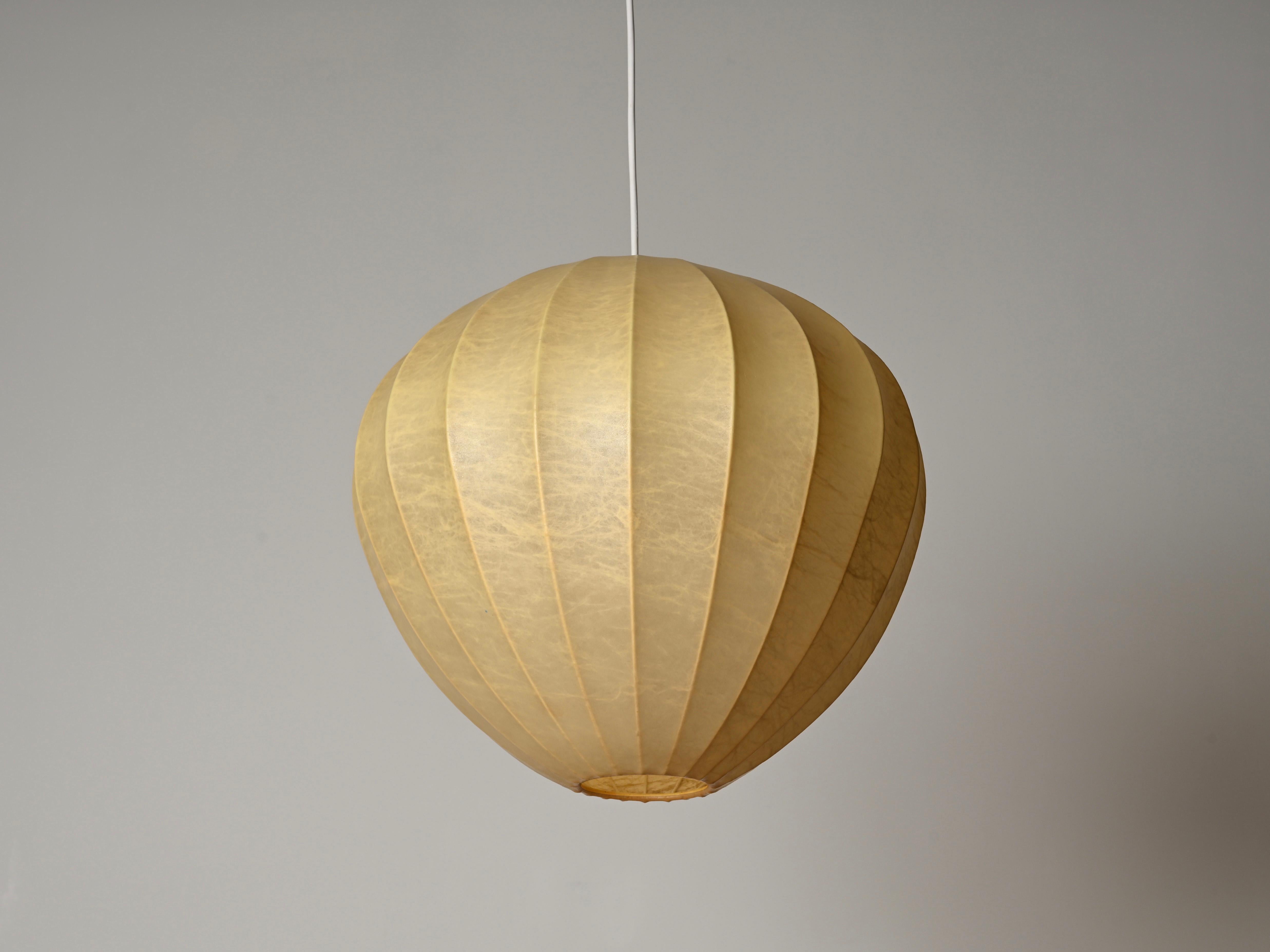 Spettacolare ciondolo a forma di bozzolo a forma di losanga della metà del secolo scorso con una splendida patina beige uniforme. Questo lampadario unico nel suo genere è stato disegnato da Achille Castiglioni in Italia negli anni '60. 

In
