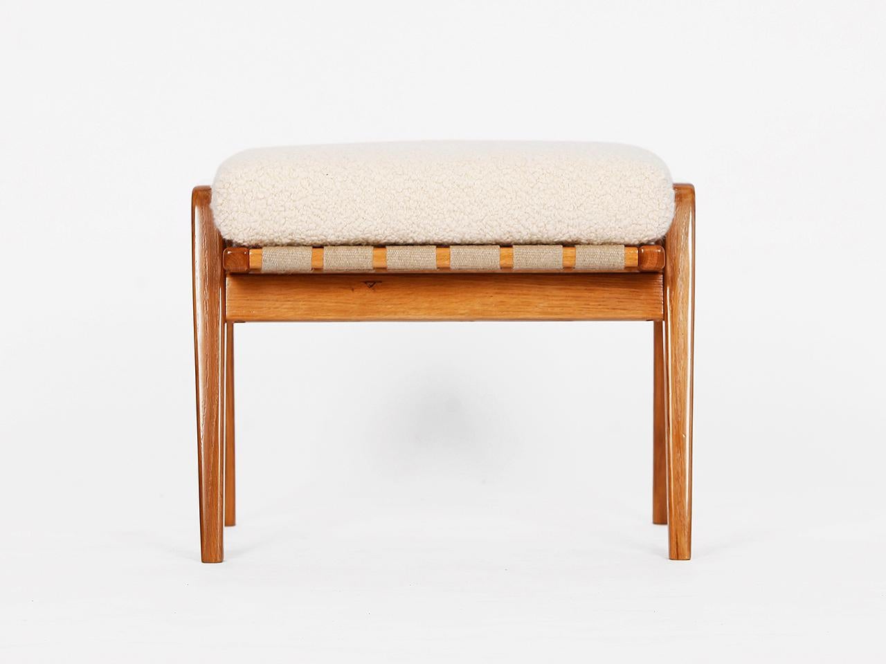 This midcentury stool footstool was made in the 1960s in former Czechoslovakia. Solid ash with hemp straps. The removable upholstery consists of a coconut fiber core, covered with a wonderful bouclé fabric made of soft wool and alpaca from the