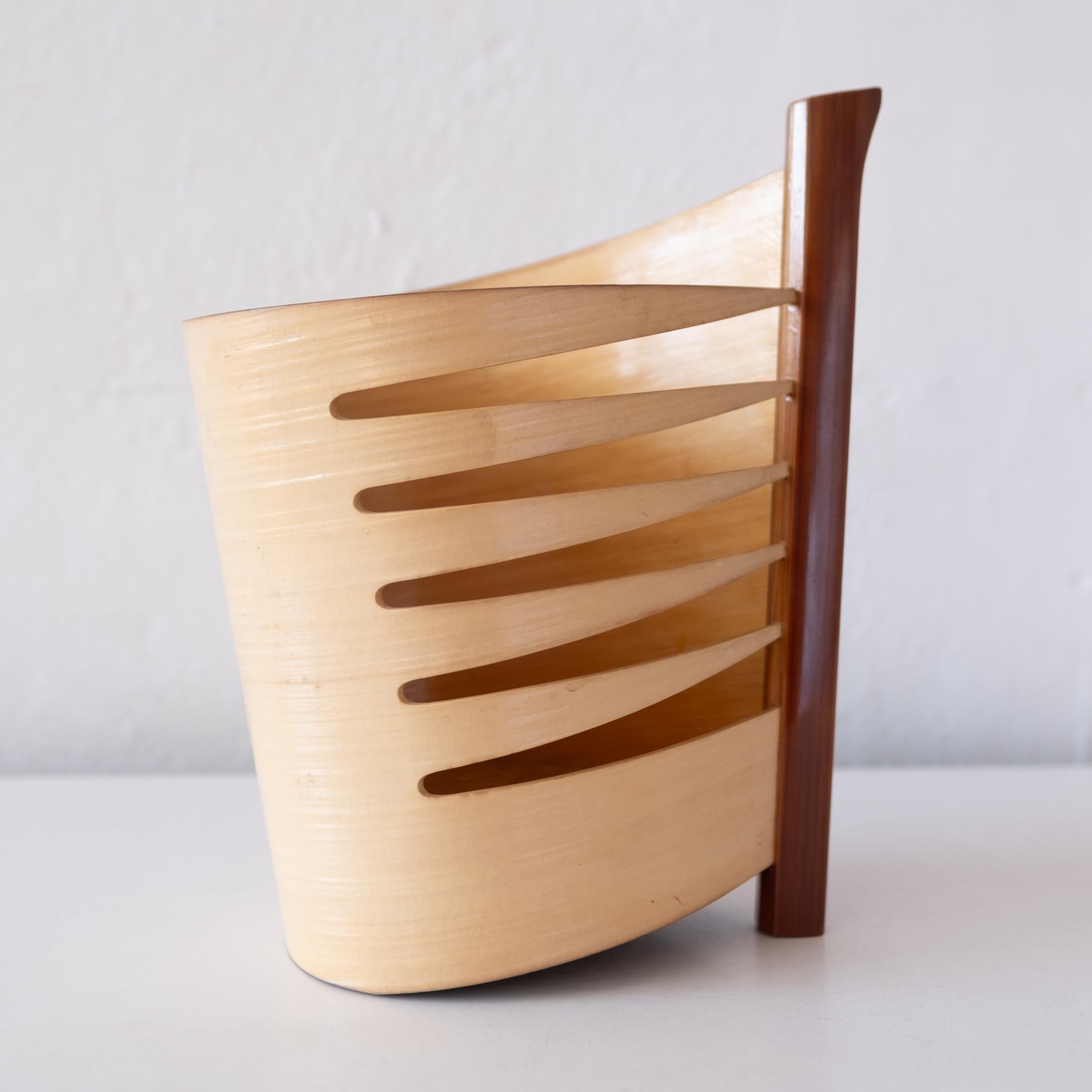 A finely crafted bent bamboo and wood sculptural vase. Oxblood red lacquered bottom. Japan, 1960