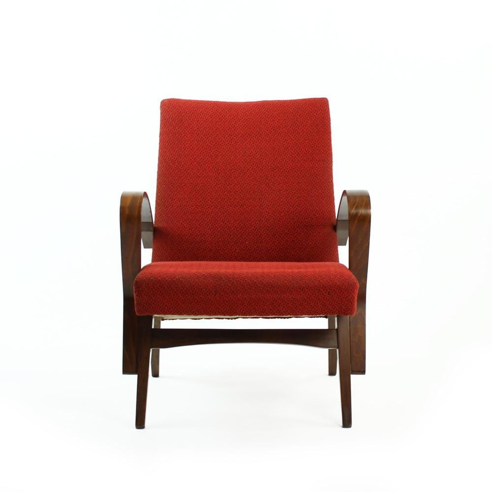Amazing armchairs with great style of design. Produced in Czechoslovakia in 1960s, the armchairs are in an original red upholstery that shows only minor wear. Some little sun fading on the back, but it is almost not visible. Otherwise really good