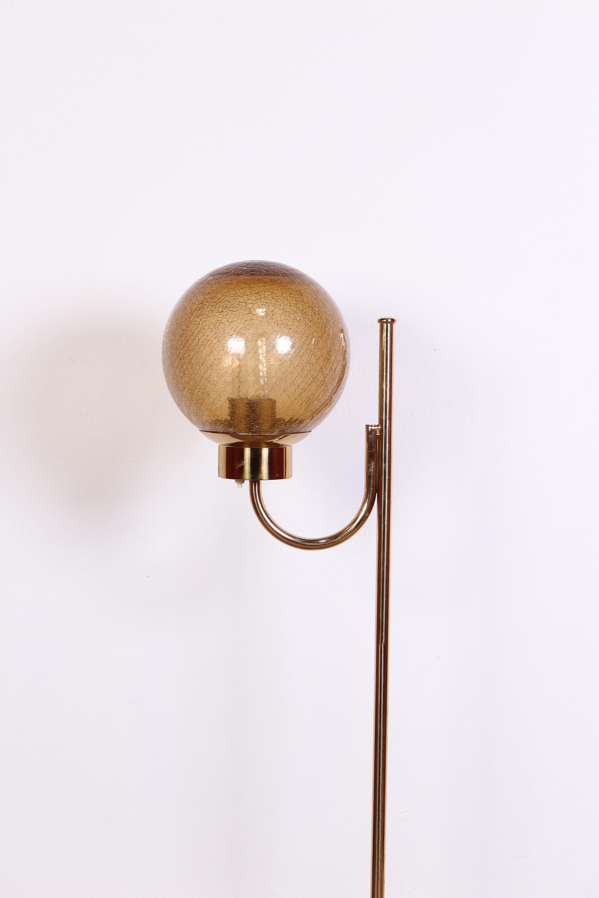 A midcentury brass floor lamp made by the Swedish manufacturer Bergboms. The model is called G-118 and is made out of brass with a round shade made out of thick glass. Very good vintage condition with minor signs of usage and patina consistent with