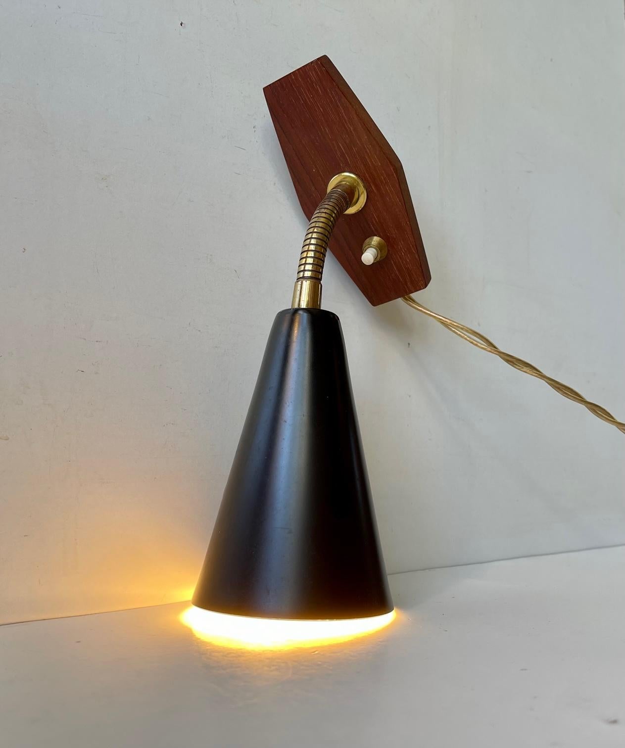 A swedish modern wall light made from teak, brass and powder coated aluminium. Designed and manufactured by ASEA in Sweden during the 1950s in a style reminiscent of Paavo Tynell and Hans Bergstrom. The light will be sold and shipped in working