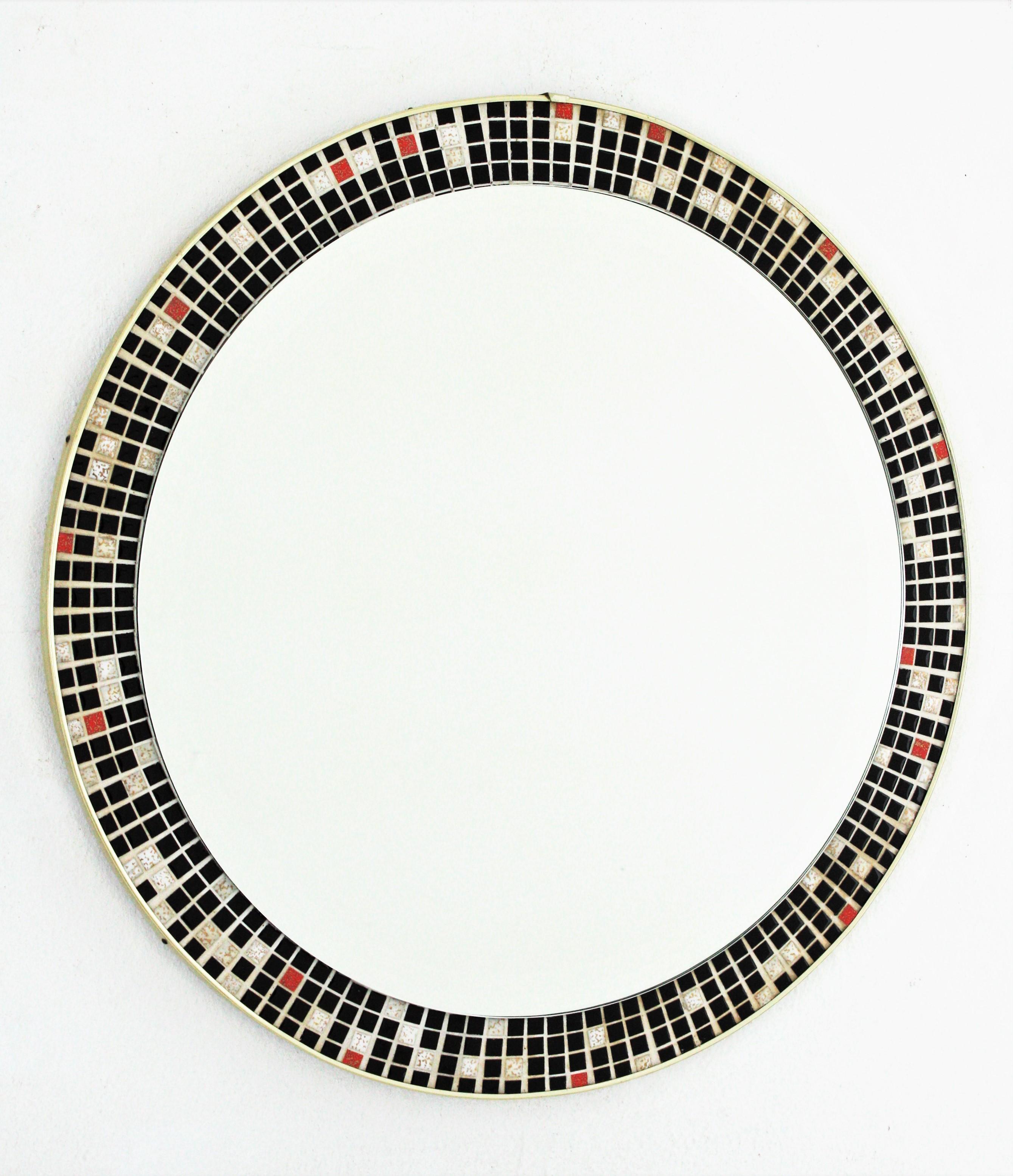 Midcentury Round Wall Mirror with Black and White Tile Mosaic Frame
Beautiful Mid-Century Modern round mirror with ceramic tile mosaic frame, Spain, 1960s.
The mosaic frame is comprised by small ceramic tiles in black color accented by some ones in