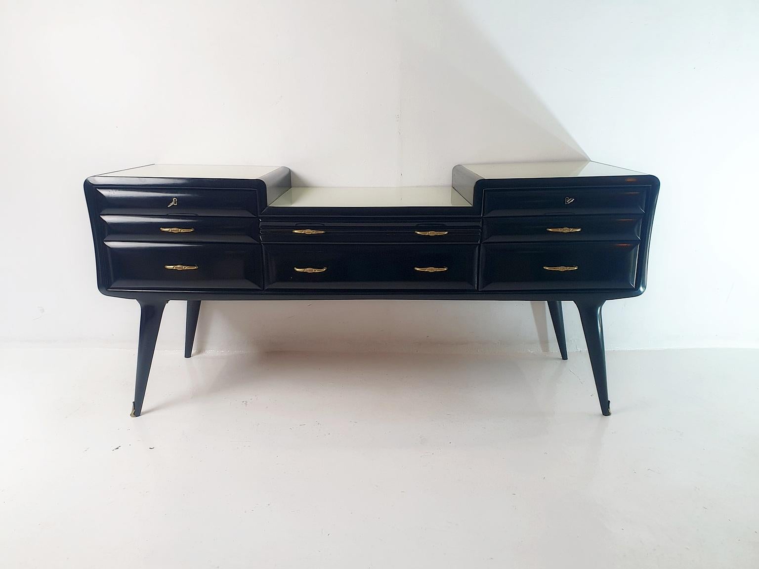 This Italian midcentury credenza crafted with lightweight materials, the piece showcases multiple beveled drawers. In combination with it's angular legs as well as glass tops it reflects the 1950's cutting-edge design.

Recently, the credenza