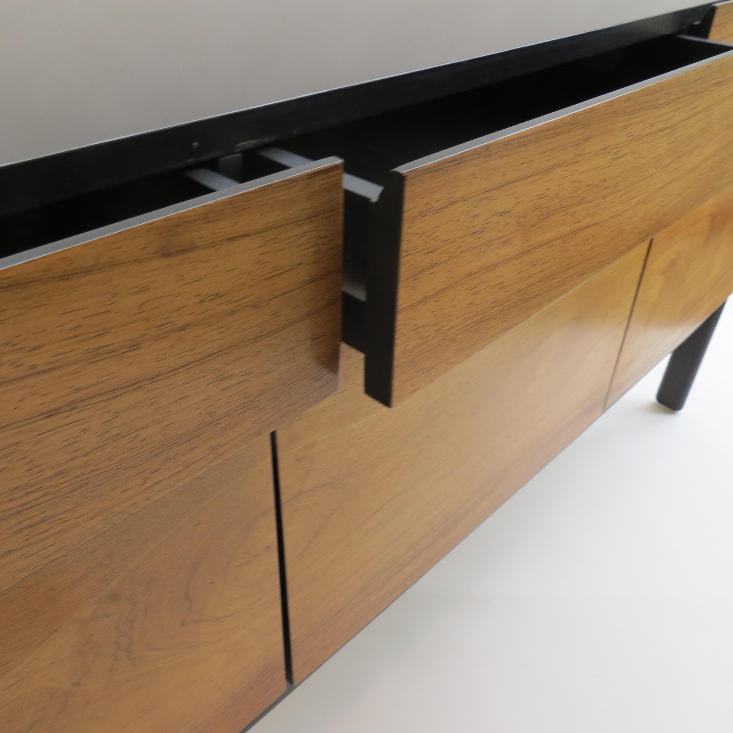 Midcentury sideboard with rosewood veneered doors and ebonised top and sides. Designed and produced by Arkana or Bath Cabinet Makers (they were both owned by the same group). Dated to the rear of the drawer 5 Nov 1970.
In good vintage condition.