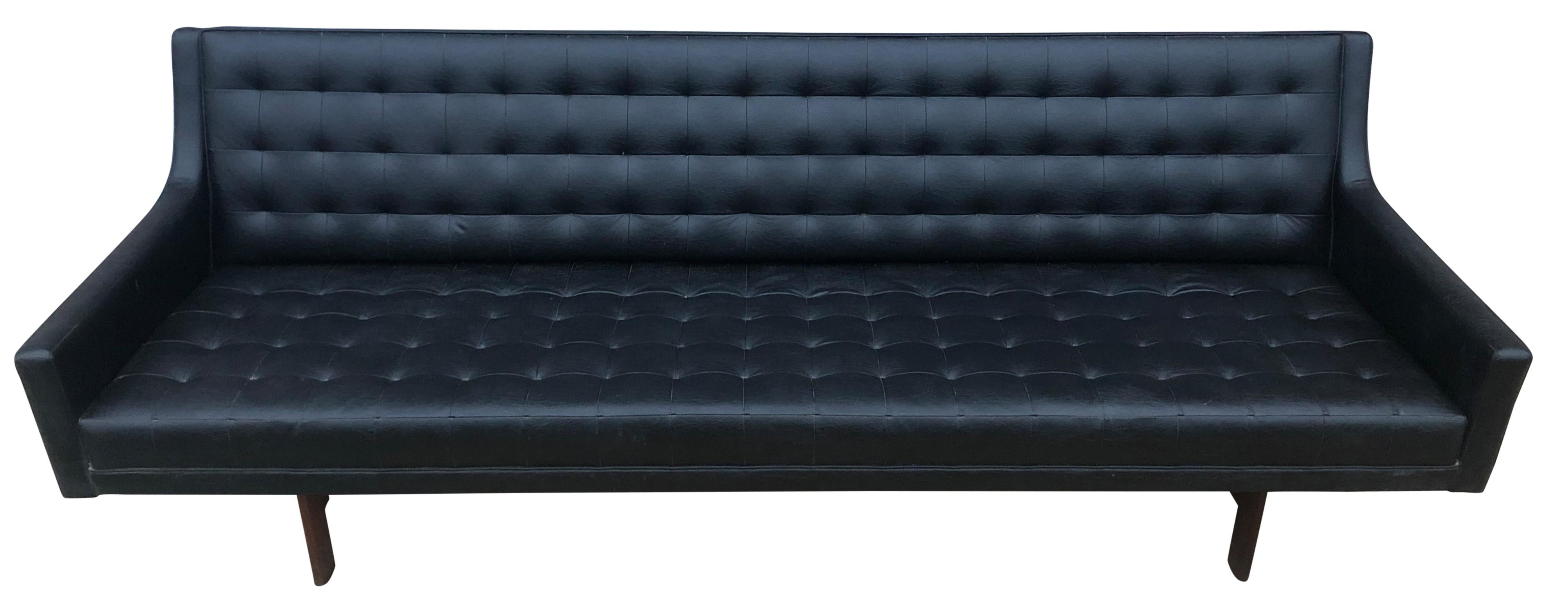 Beautiful unique Mid-Century Modern black faux leather vinyl tufted sofa with walnut wood base and leather by Patrician. Very soft ribbed black faux leather with texture on hardwood walnut frame and simple structure. Low seating 15