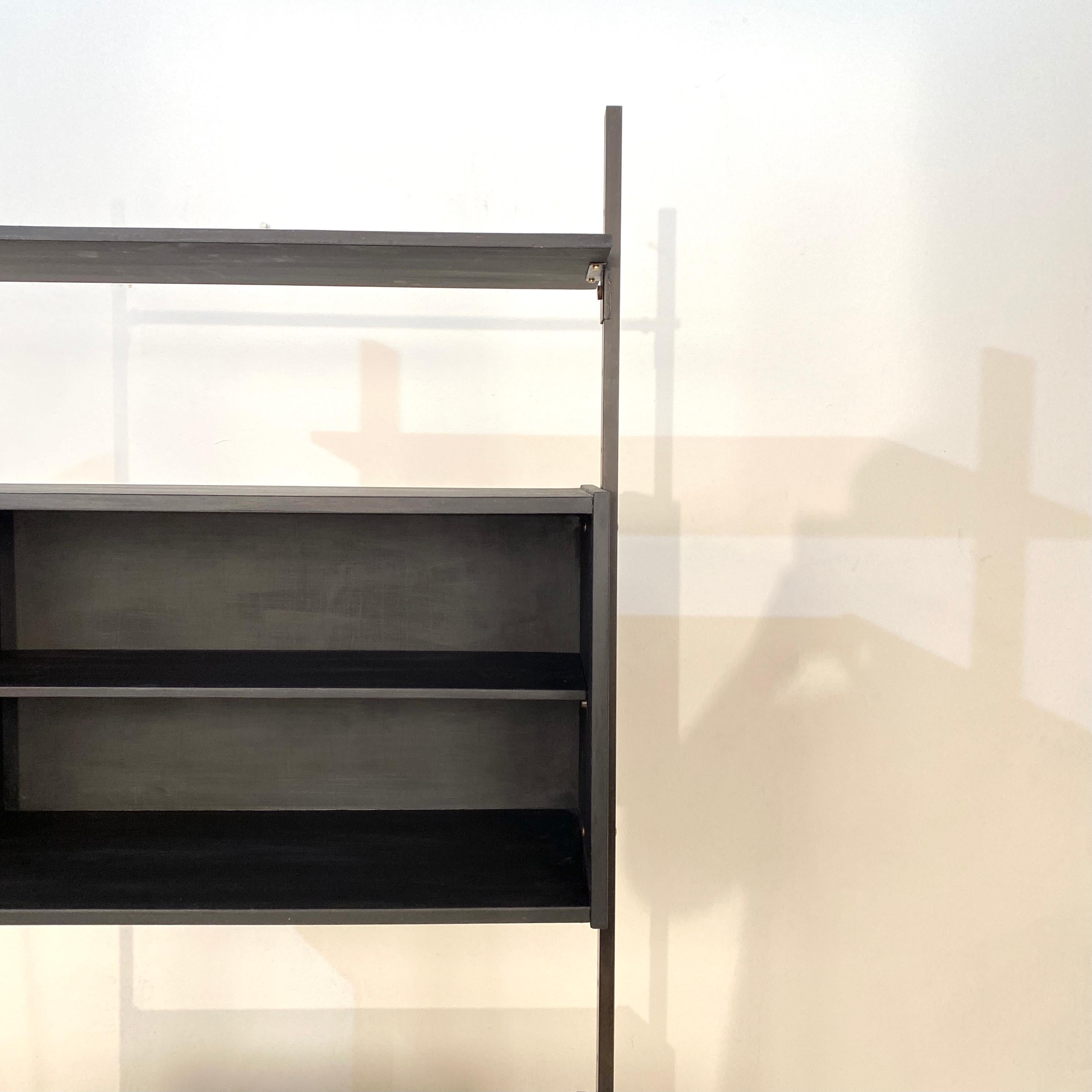 This elegant midcentury Italian shelf by BR Italian was made circa 1960.
It has black lacquered metal legs of frame and wood shelfing. It has got one open corpus and one corpus with 2 doors. There is also one single shelf board. 

A unique piece