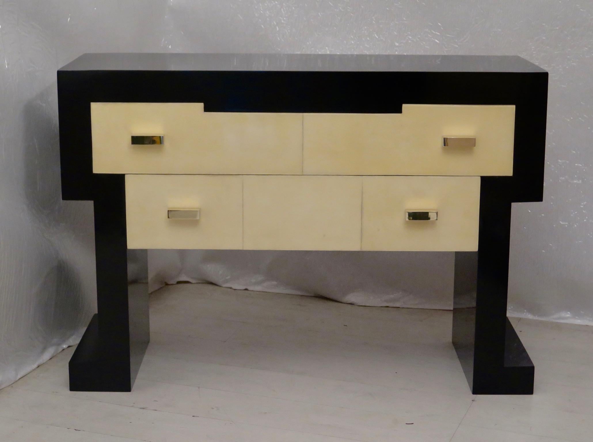 Italian midcentury chest of drawers. Body completely lacquered in black shellac. On the front two drawers, one smaller and one larger, covered in parchment leather. The parchment leather was then polished with transparent resin. Two brass handles