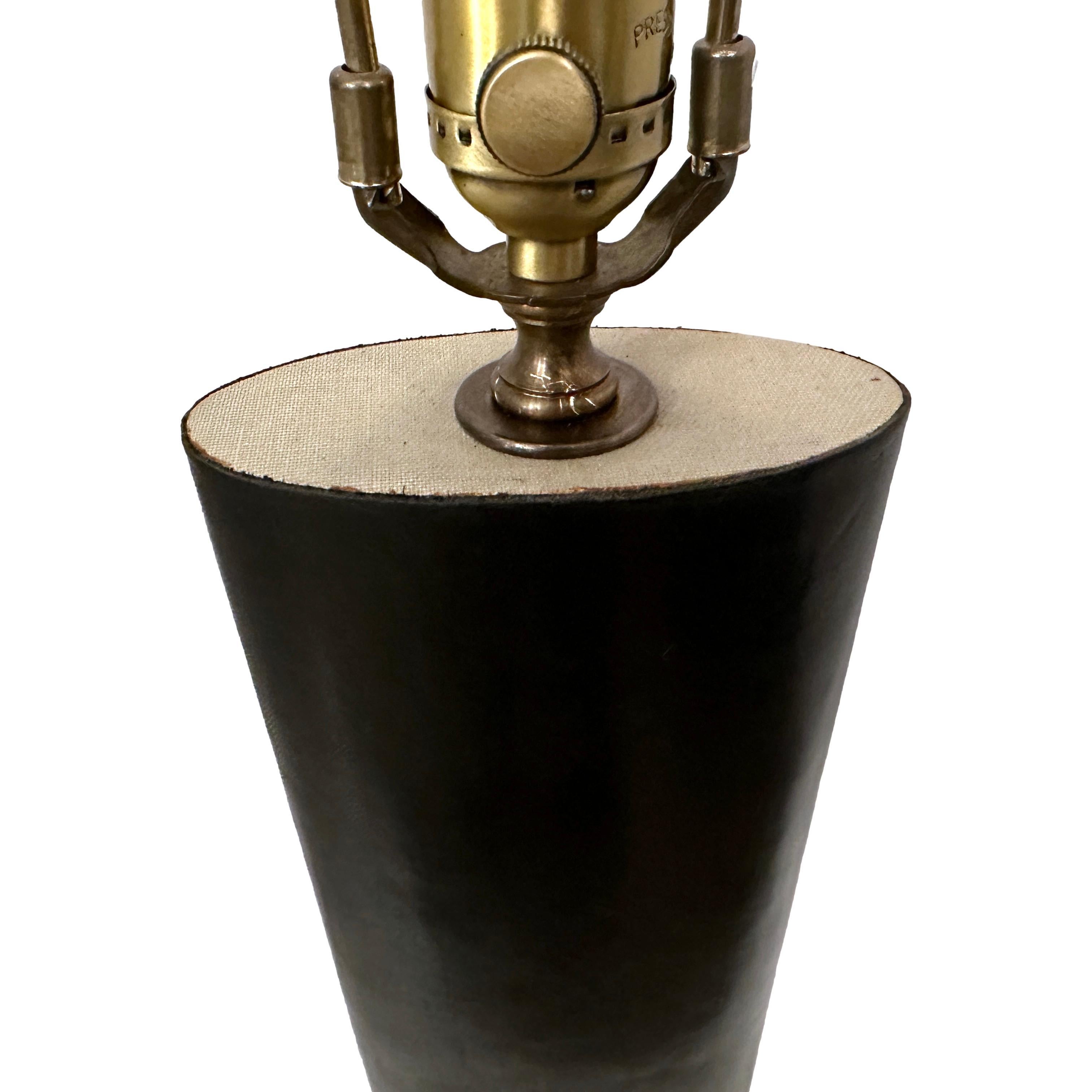 A circa 1950's French black leather table lamp.

Measurements:
Height of body: 19
