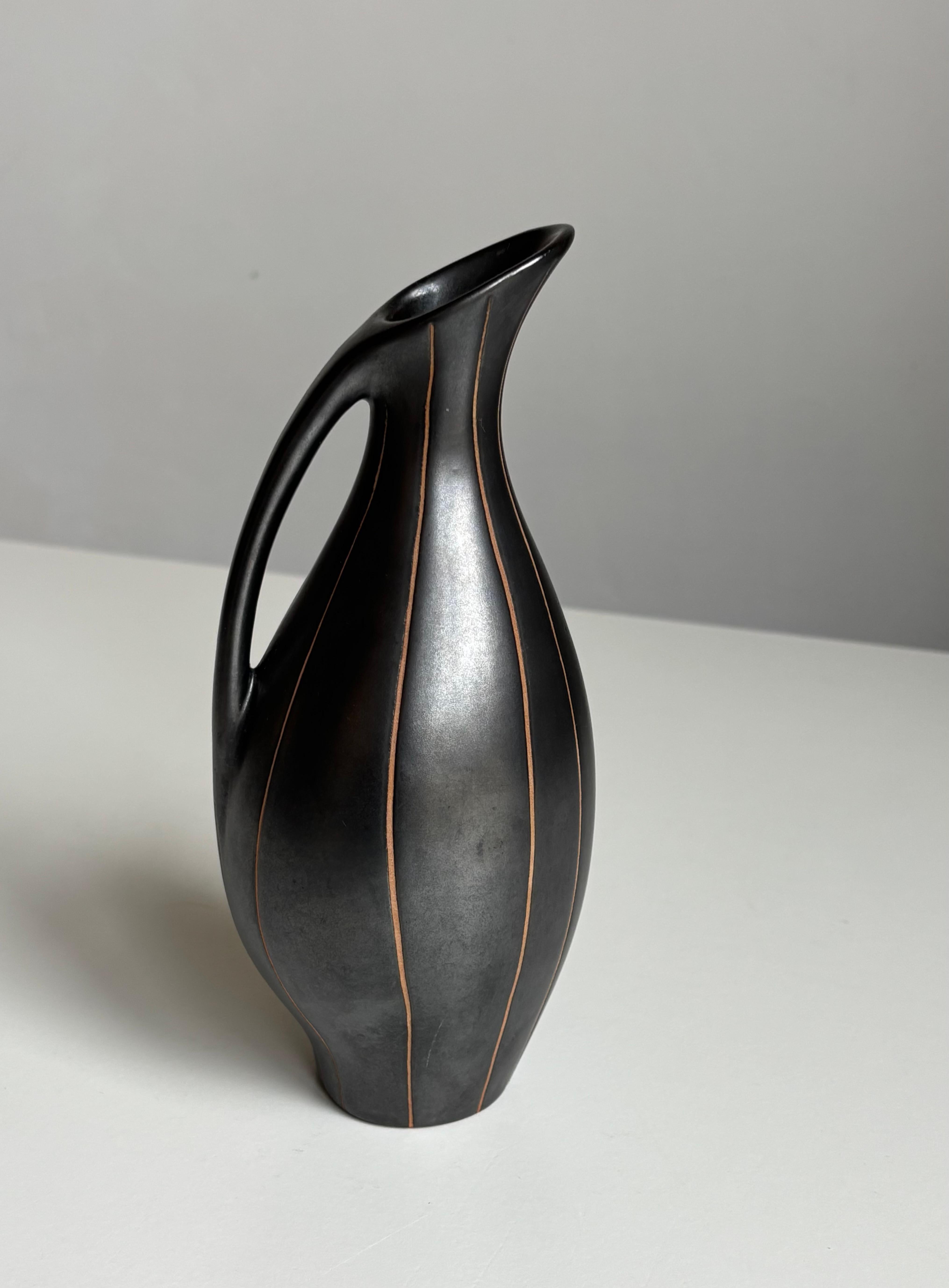 Elegante vaso a brocca modernista in nero lucido. Linee verticali intagliate a mano dalla cima alla base. Firmato dall'artista.
Bellissime condizioni vintage.
Scandinavia, anni '1960.